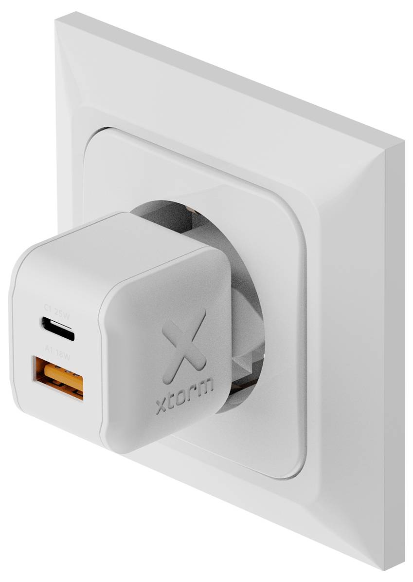 Weiße Xcharm-Wandladegerät, das in eine Wandsteckdose eingesteckt ist, mit einem sichtbaren USB-C-Anschluss und einem USB-A-Anschluss.