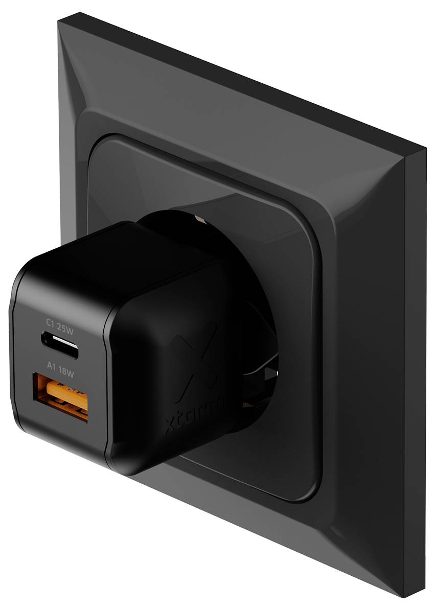 Schwarze Wandsteckdose mit angeschlossenem Xqisit-Ladegerät, das auf der Vorderseite USB-C 25W- und USB-A 18W-Anschlüsse zeigt.