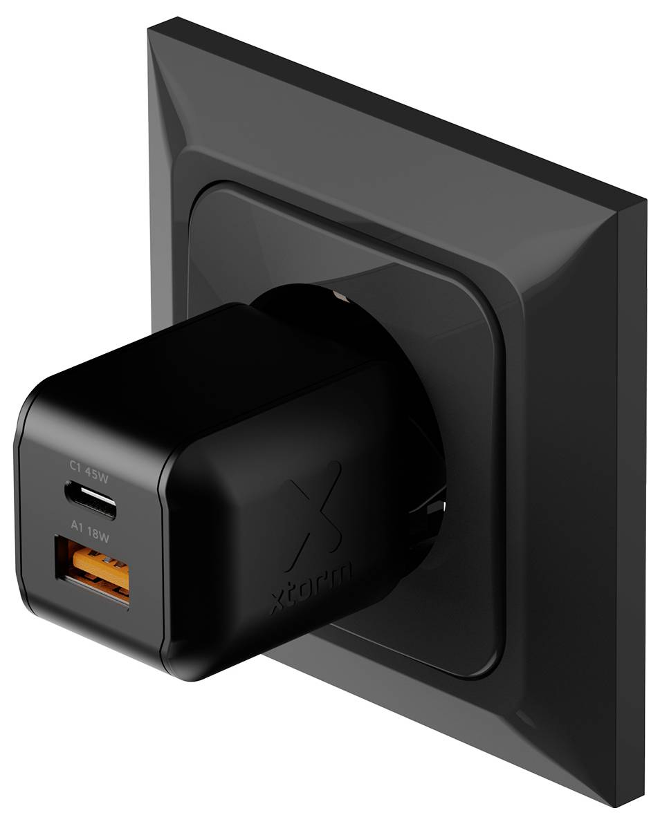 Schwarzes Wandladegerät mit USB-C und orangefarbigen USB-A-Anschlüssen, das in eine Wandsteckdose eingesteckt ist