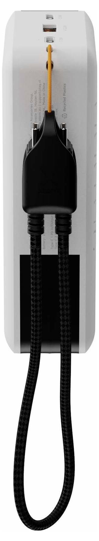 Weiße an der Wand montierte Vorrichtung mit einem schwarzen Handset, das vorne angedockt ist, und einem aufgerollten schwarzen Kabel, das darunter hängt.