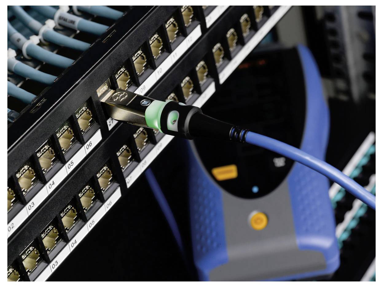 Nahaufnahme eines blauen Ethernet-Kabels, das in ein Netzwerk-Switch-Rack eingesteckt ist, was eine Server- oder Datencenterverbindung anzeigt.