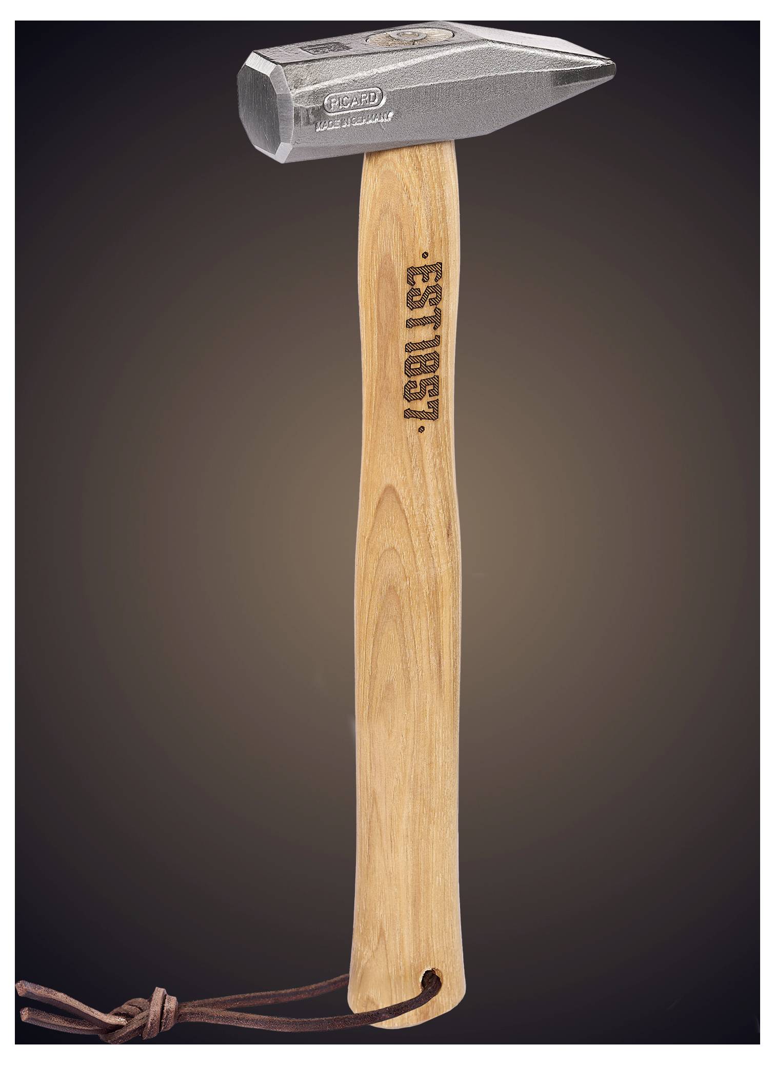 Ein Krallenhammer mit Holzgriff und Lederriemen hängt vor einem dunklen Hintergrund und trägt die Aufschrift „BEST USA