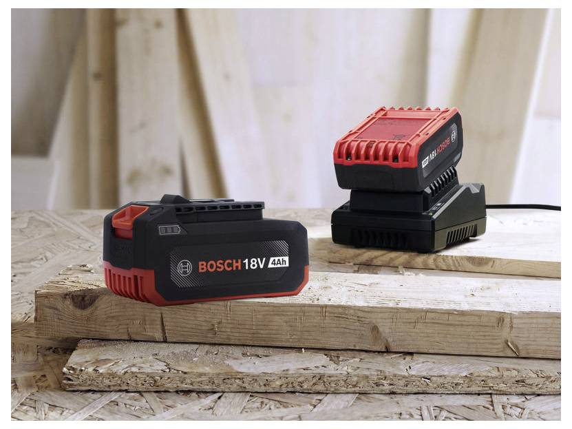 Bosch 18V 4Ah Batteriepack im Vordergrund, mit einem Bosch Batterieladegerät und einer weiteren Batterie auf einer hölzernen Werkbank.