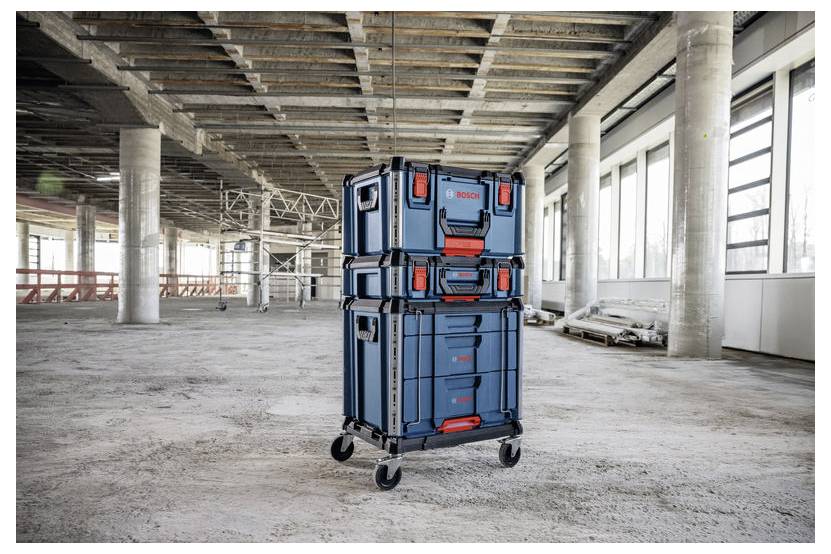 Stapel blauer fahrbarer Lagerkästen auf einem Wagen in einem unfertigen Betongebäude im Bau.