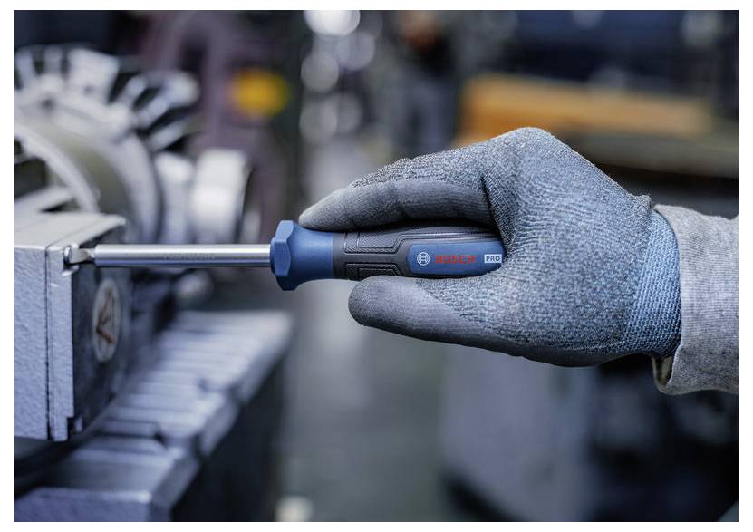 Behandschuhte Hand verwendet einen Bosch-Schraubenzieher zum Festziehen einer Schraube in einem Metallschraubstock, was auf Reparatur- oder Montagearbeiten hindeutet.