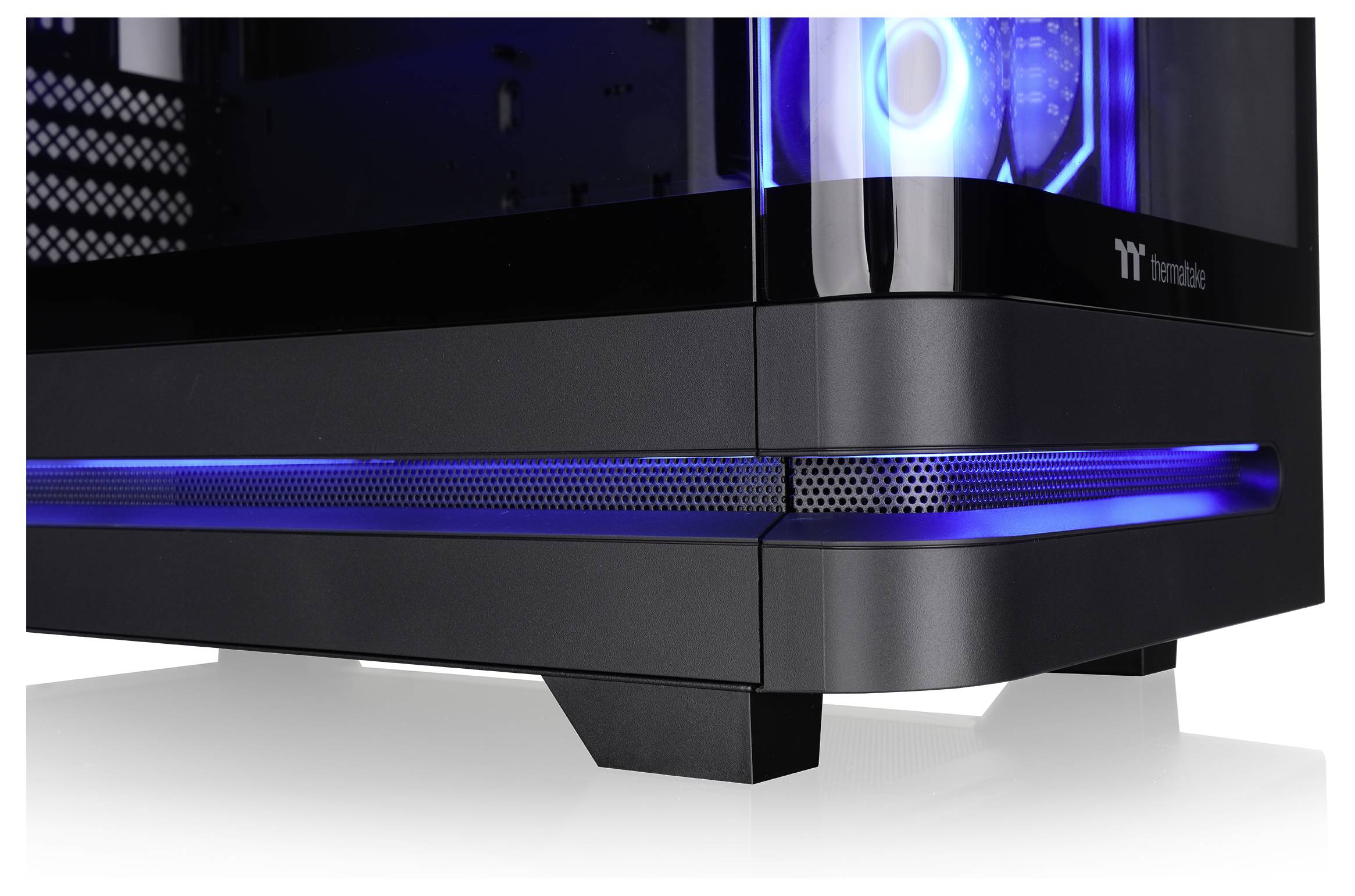 Nahaufnahme eines schwarzen Thermaltake Gaming-PC-Gehäuses mit blauer LED-Beleuchtung und einem Seitenpanel aus gehärtetem Glas.