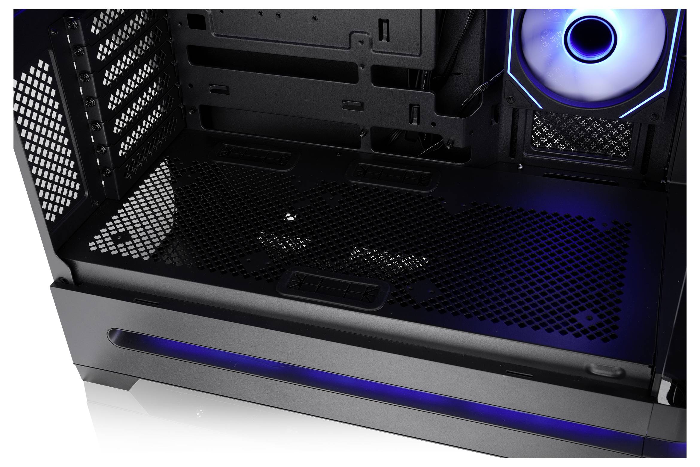 Leeres Gaming-PC-Gehäuse-Inneres mit schwarzen Gitterpanelen, blauem LED-Ringventilator und blauer Akzentbeleuchtung unten.