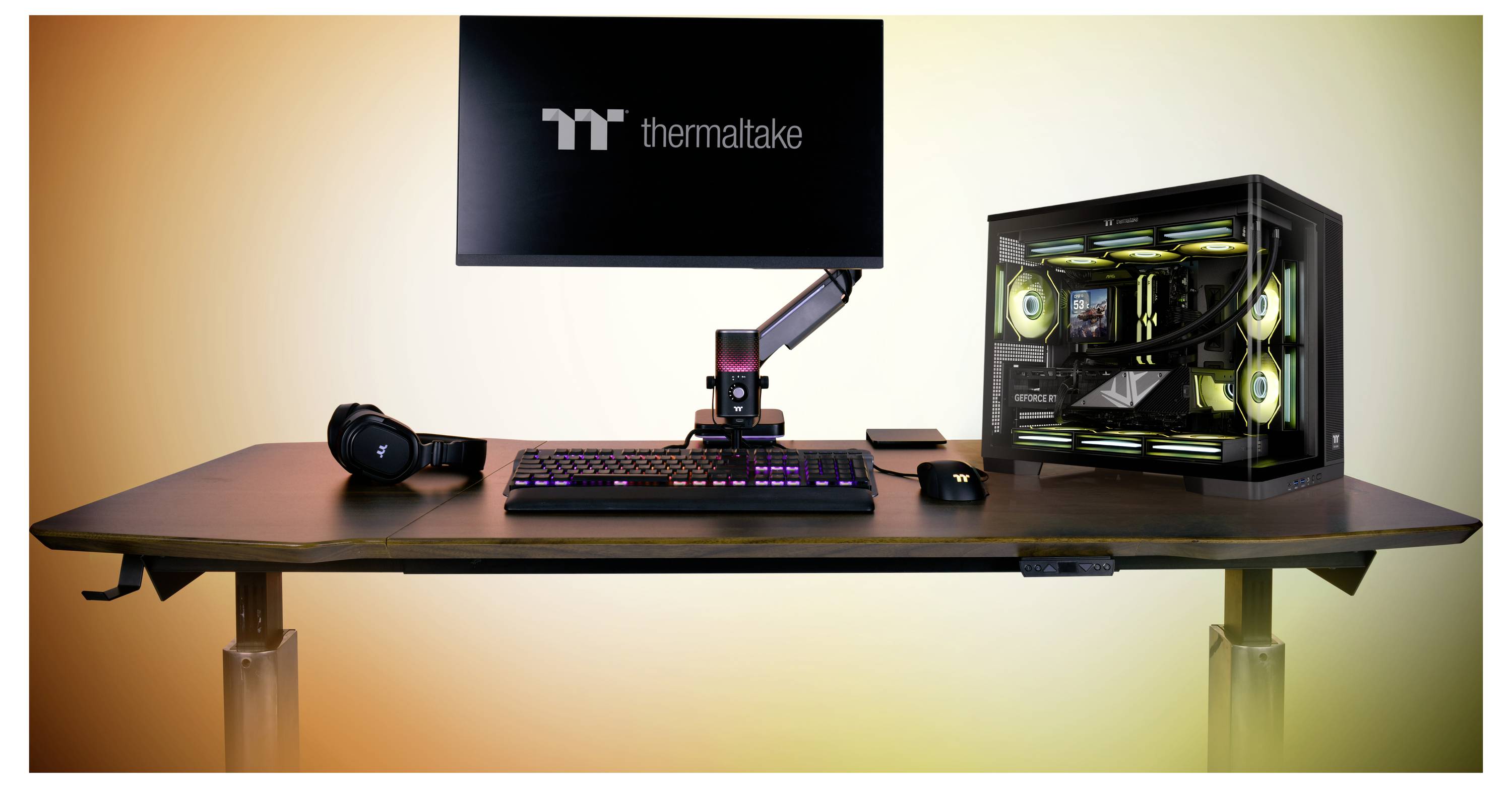 Gaming-Schreibtisch-Setup mit Monitor, Tastatur, Maus, Headset, Mikrofonarm und PC mit Glasseitenwänden und RGB-Beleuchtung auf einem Holzschreibtisch mit warmer Hintergrundbeleuchtung.