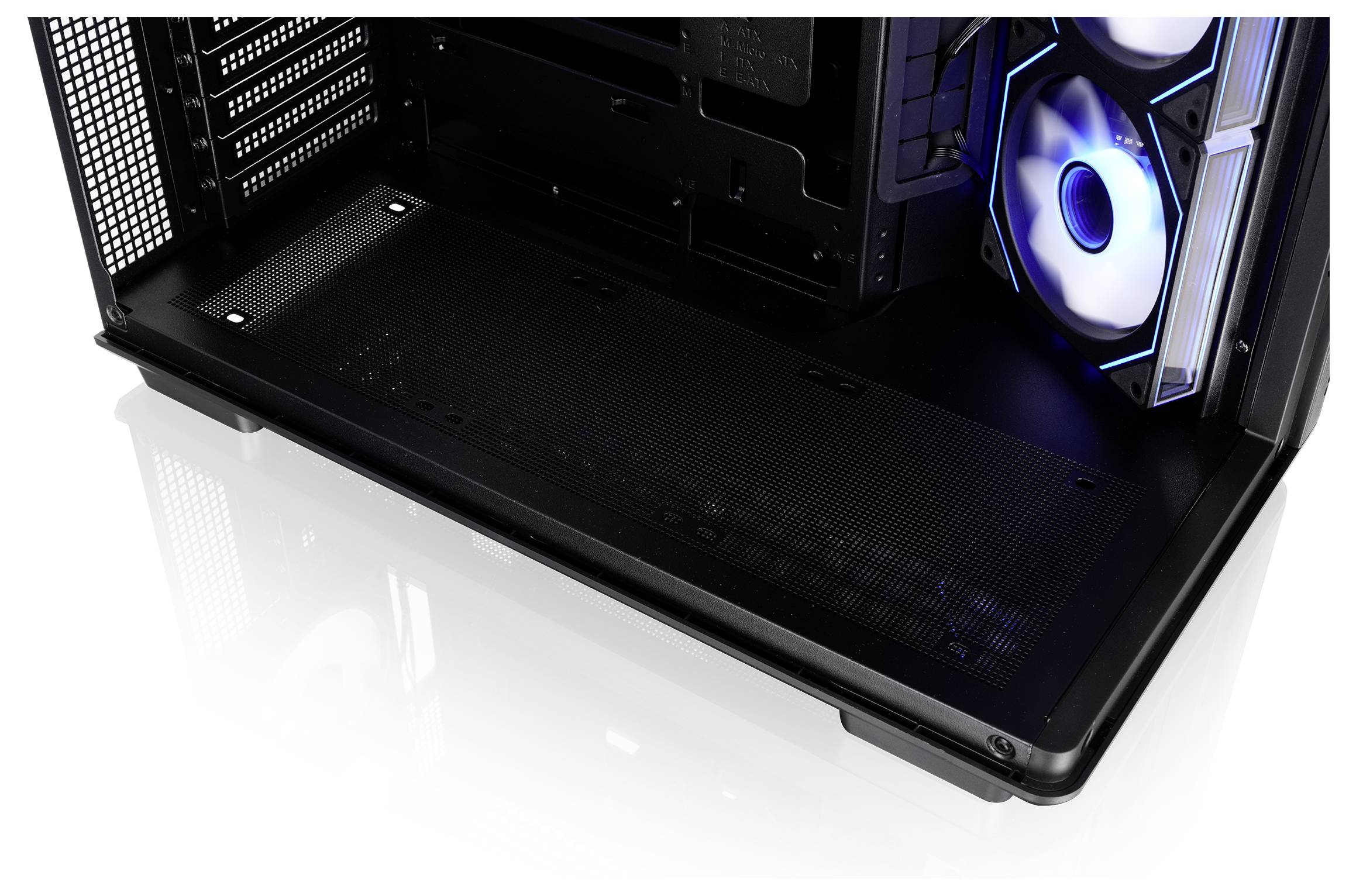 Innenseite eines Desktop-PC-Gehäuses mit einer großen schwarzen Netzteil-Abdeckung und einem blau beleuchteten Kühlventilator auf der rechten Seite.