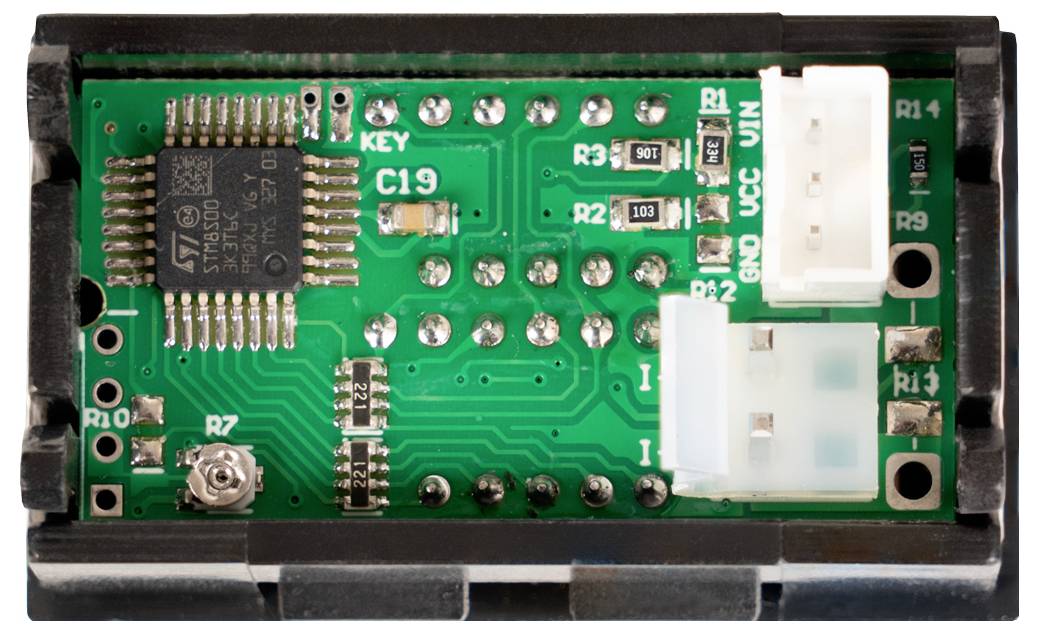 Nahaufnahme einer kleinen Leiterplatte mit einem ST-Mikrocontroller, zwei weißen Steckverbindern und beschrifteten Lötpads/Komponenten.