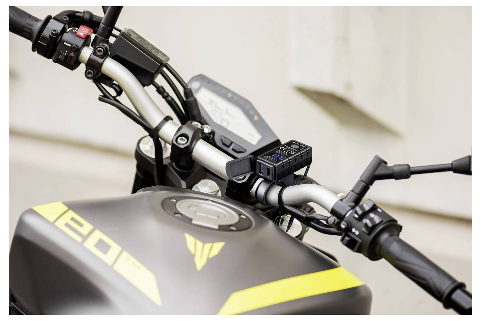Nahaufnahme eines Yamaha-Motorrad-Lenkers und Kraftstofftanks, die die Bedienelemente, das Display und die gelbe Kennzeichnung "E20" zeigen.