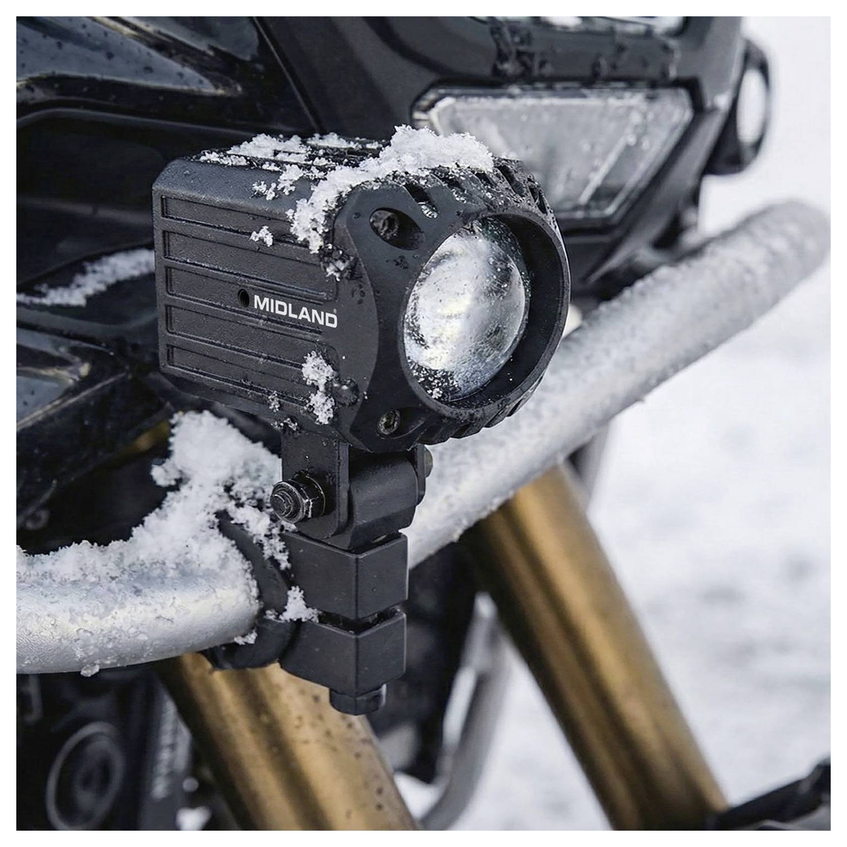 Schneebedecktes Midland-Zusatzlicht, das auf einem Motorrad-Sturzpügel in einer Winterszene montiert ist.