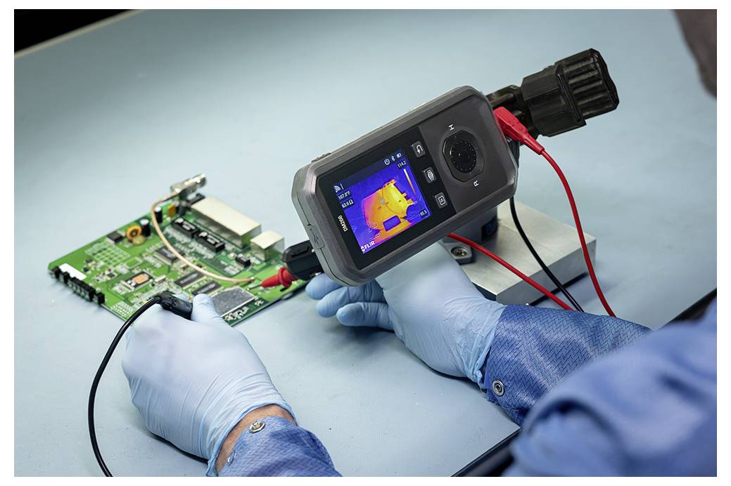 Der Techniker nutzt eine Wärmekamera zur Überprüfung einer Leiterplatte und prüft dabei während der elektronischen Diagnose auf Wärmequellen.