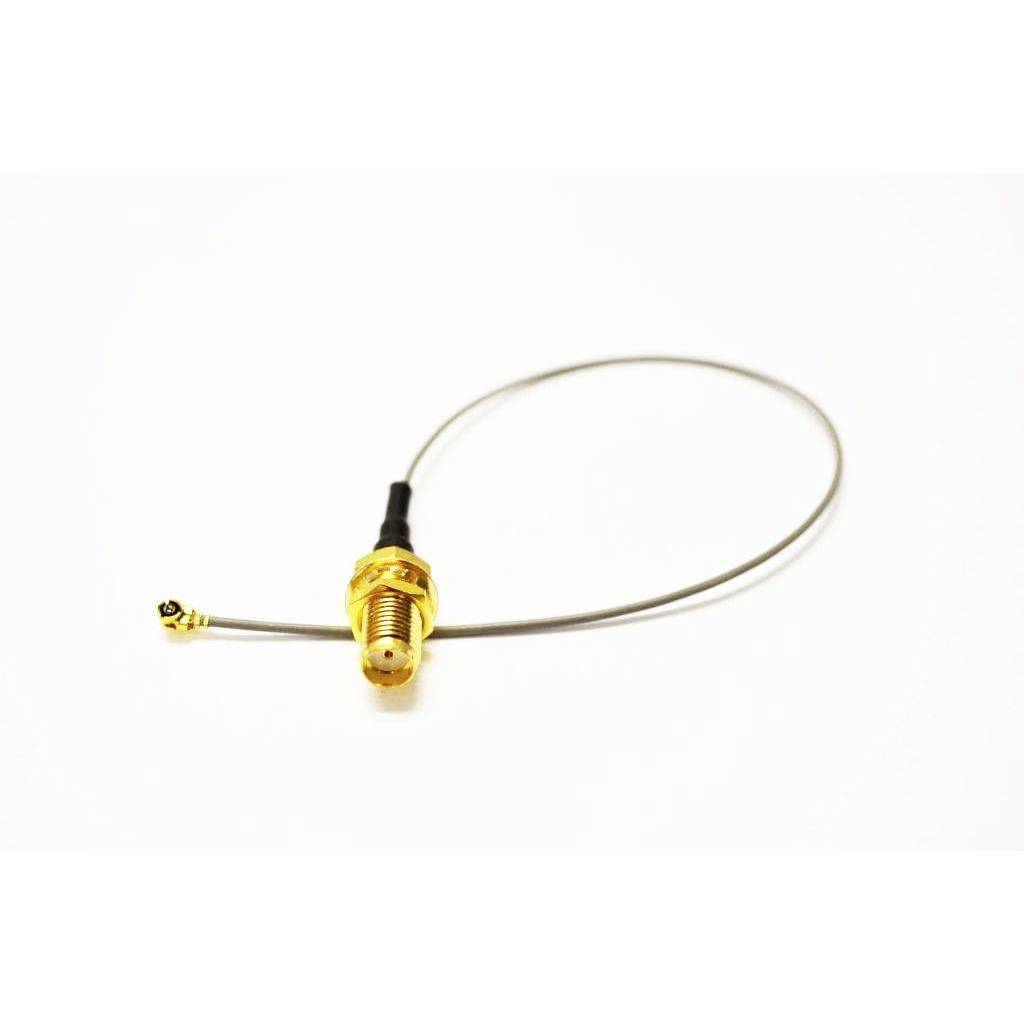 Vergoldetes koaxiales HF-Antennenkabel mit kleinem Stecker, aufgerollt auf einem schlichten weißen Hintergrund.