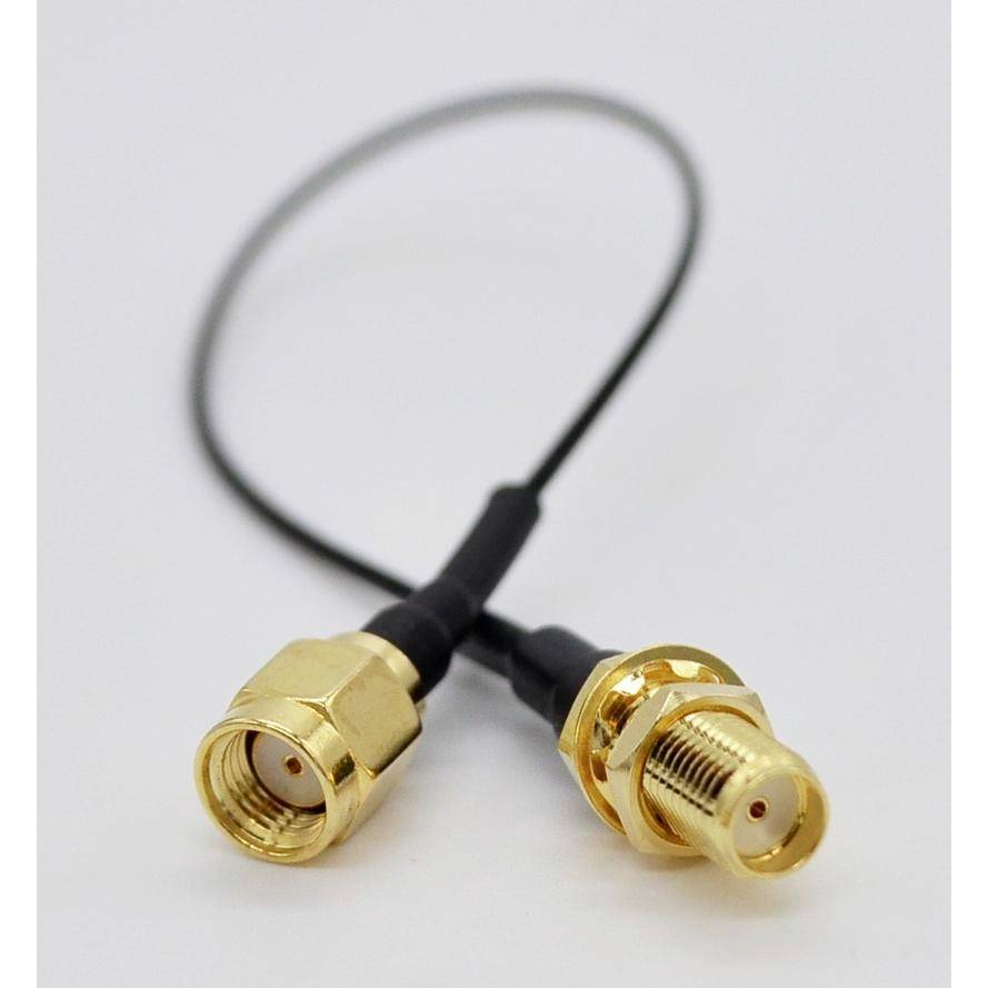 Zwei goldene koaxiale Steckverbinder auf einem kurzen schwarzen Kabel, dargestellt vor einem einfachen hellen Hintergrund.