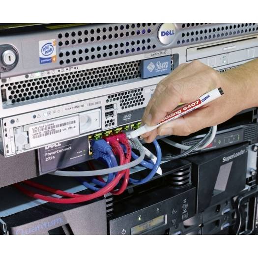 Eine Hand steckt ein Netzwerkkabel in ein Serverschrankgestell, verbindet farbige Ethernet-Kabel auf gestapelter Dell- und Sun-Ausrüstung in einem Rechenzentrum.