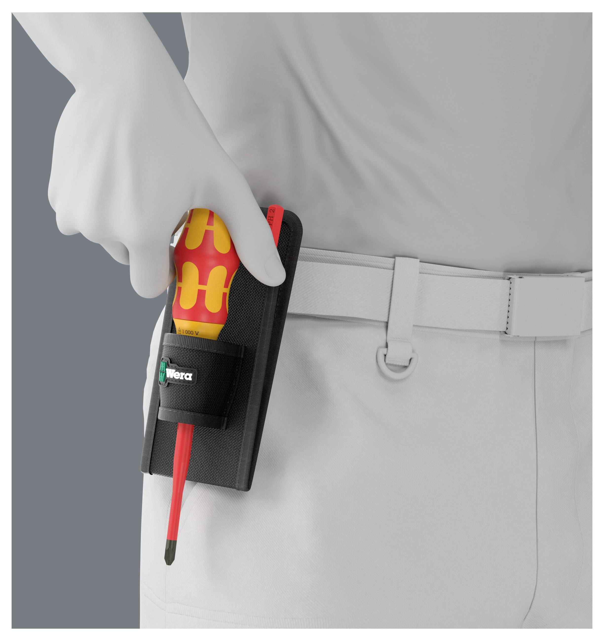 Eine behandschuhte Hand hält einen rot-gelben Schraubendreher in einem schwarzen Gürtelholster an der Taille des Trägers.