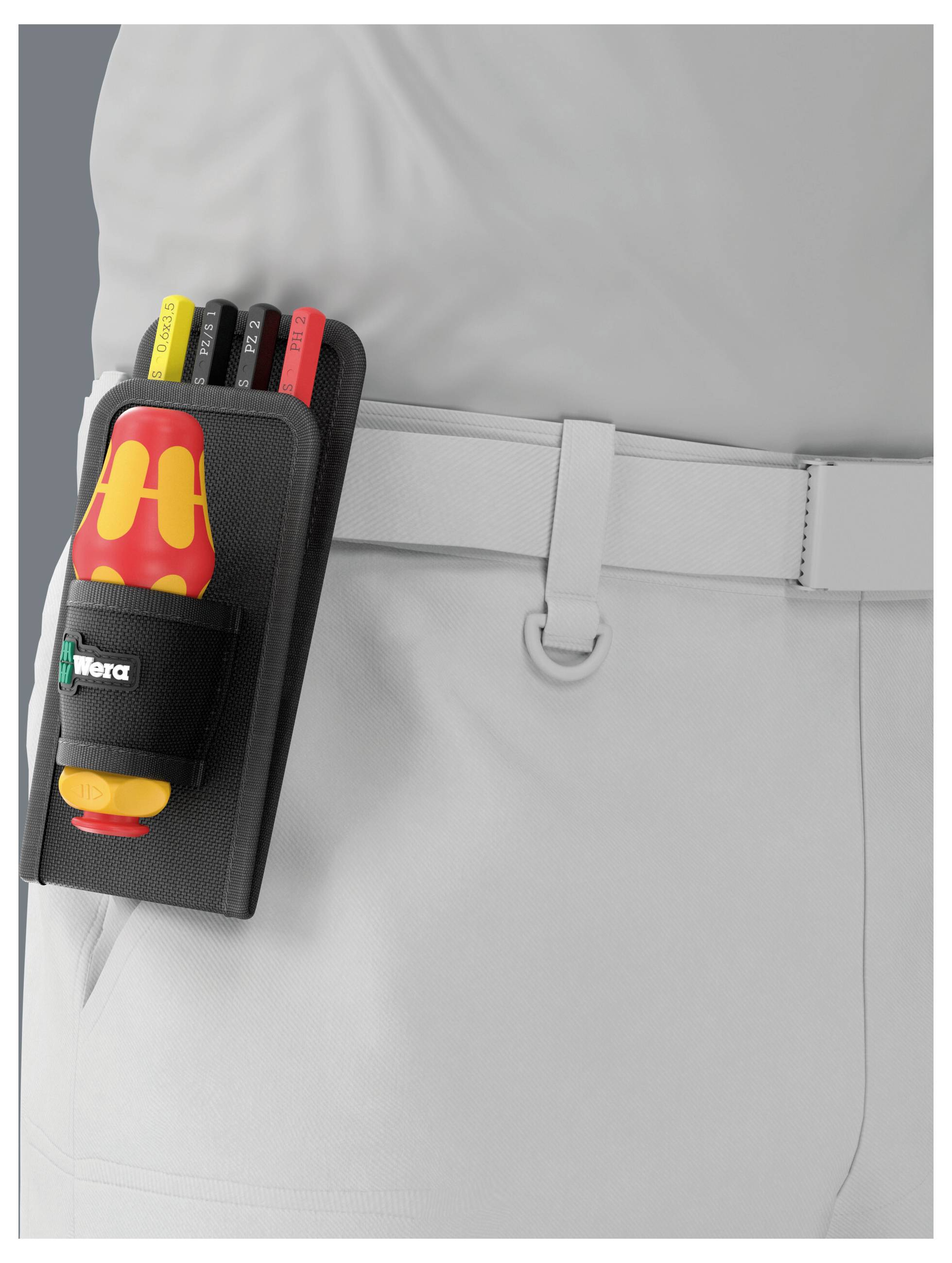 Nahaufnahme eines Arbeitergürtels mit einer Schraubendrehertasche mit isolierten Werkzeugen, die an einer grauen Uniform befestigt sind.