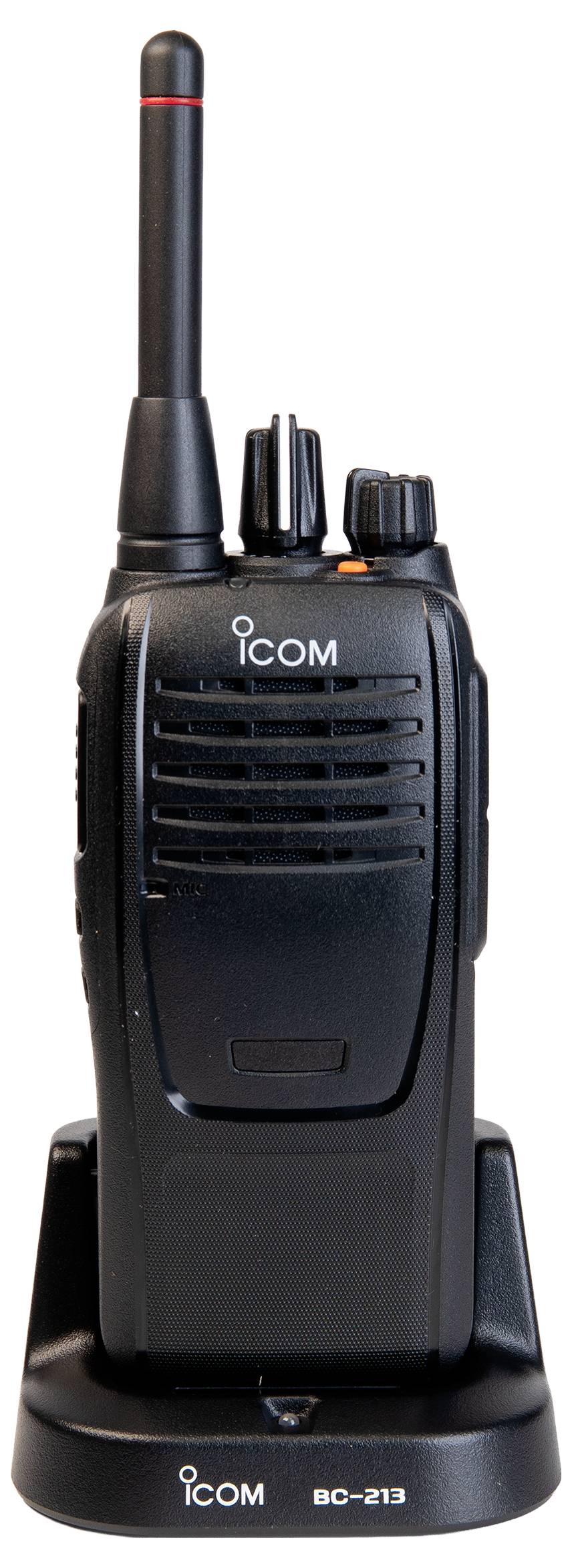 Schwarzes tragbares Icom-Funkgerät, das in einer Ladestation auf weißem Hintergrund steht.