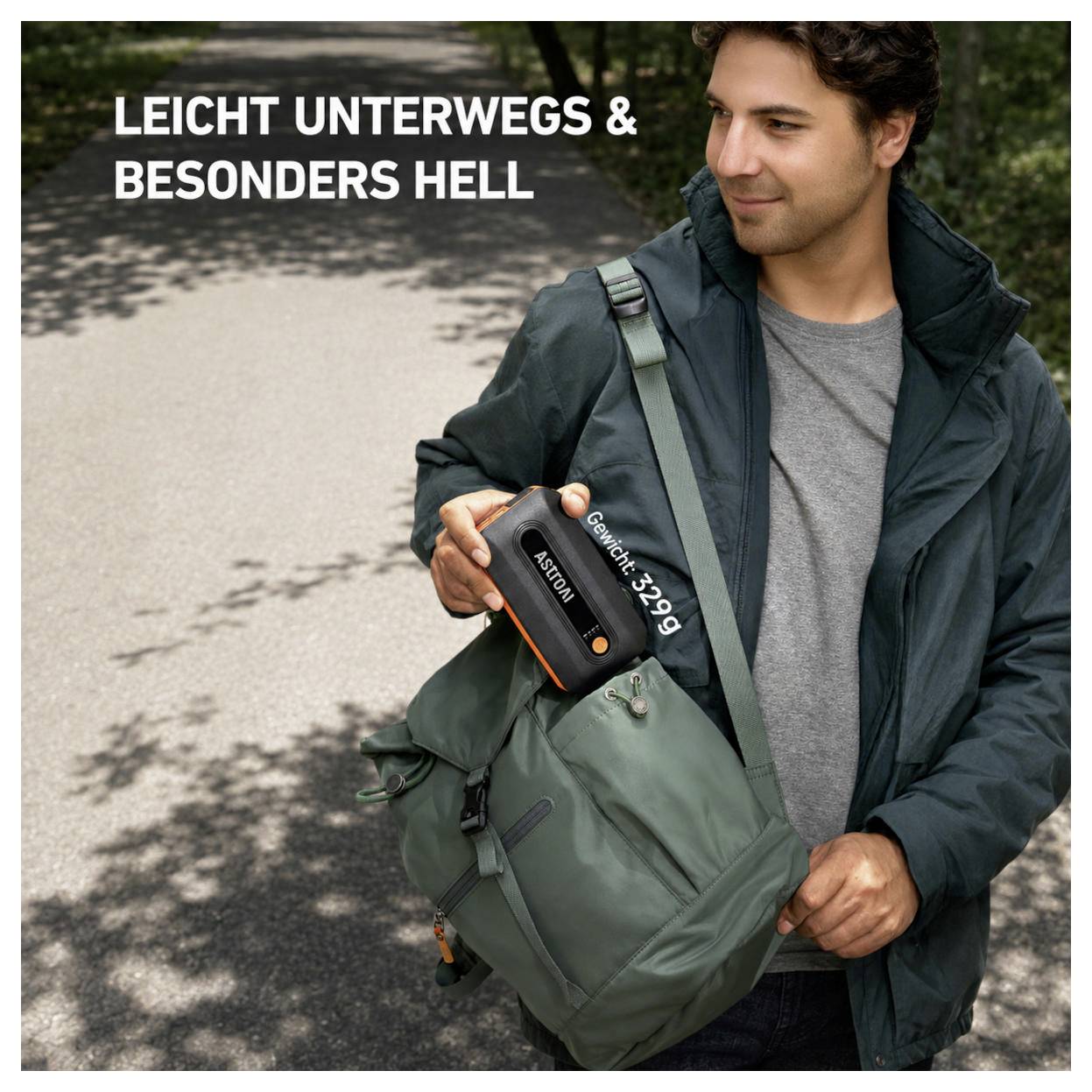 Mann, der eine kleine schwarz-orange Powerbank neben einem grünen Rucksack hält; deutscher Text sagt "LEICHT UNTERWEGS & BESONDERS HELL".