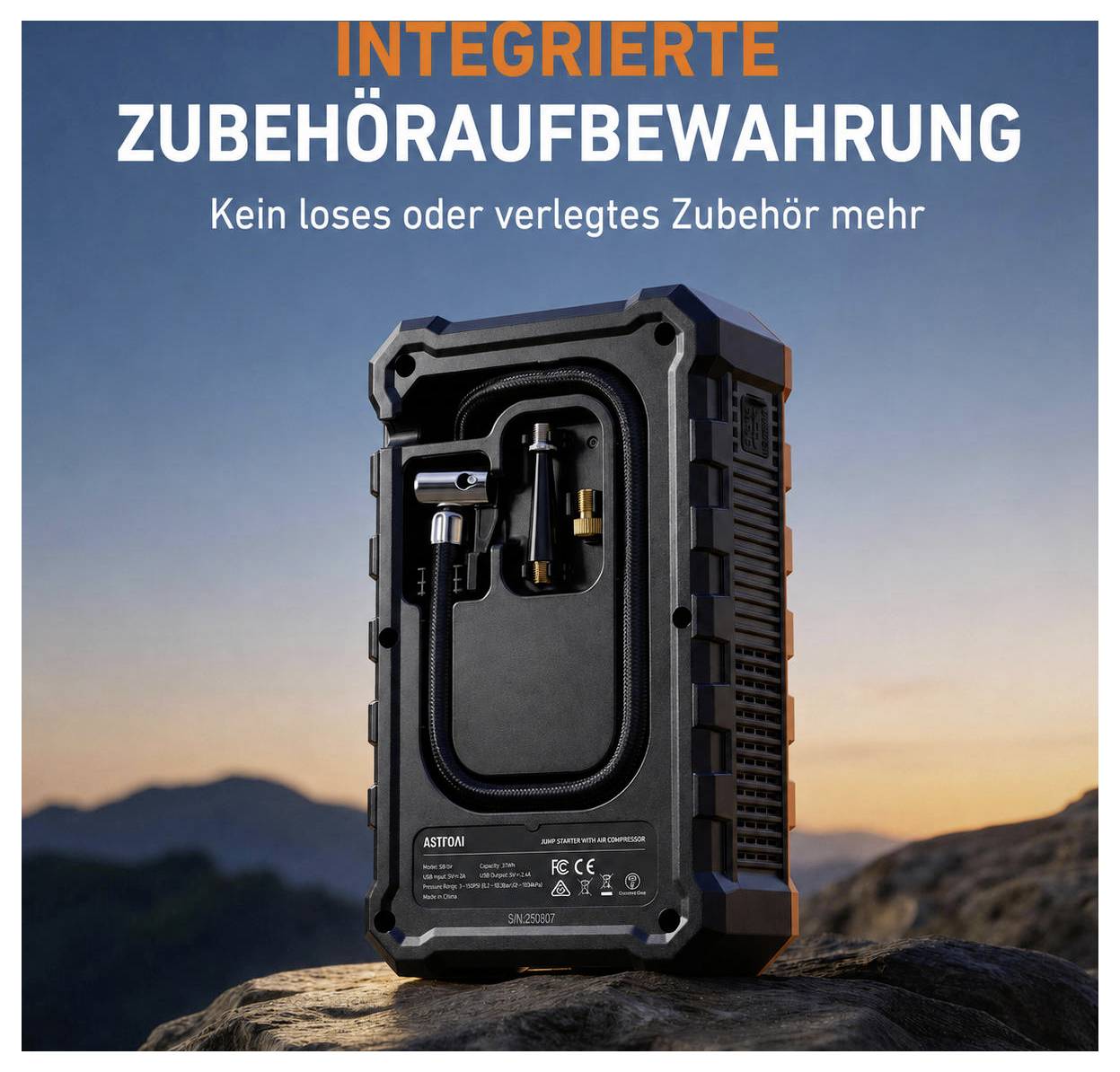 Schwarzes robustes tragbares Gerät mit integrierter Zubehörlagerung, dargestellt auf einem Stein bei Sonnenuntergang; deutscher Text lautet „Integrierte Zubehöraufbewahrung" und „Kein loses oder verlegtes Zubehör mehr".