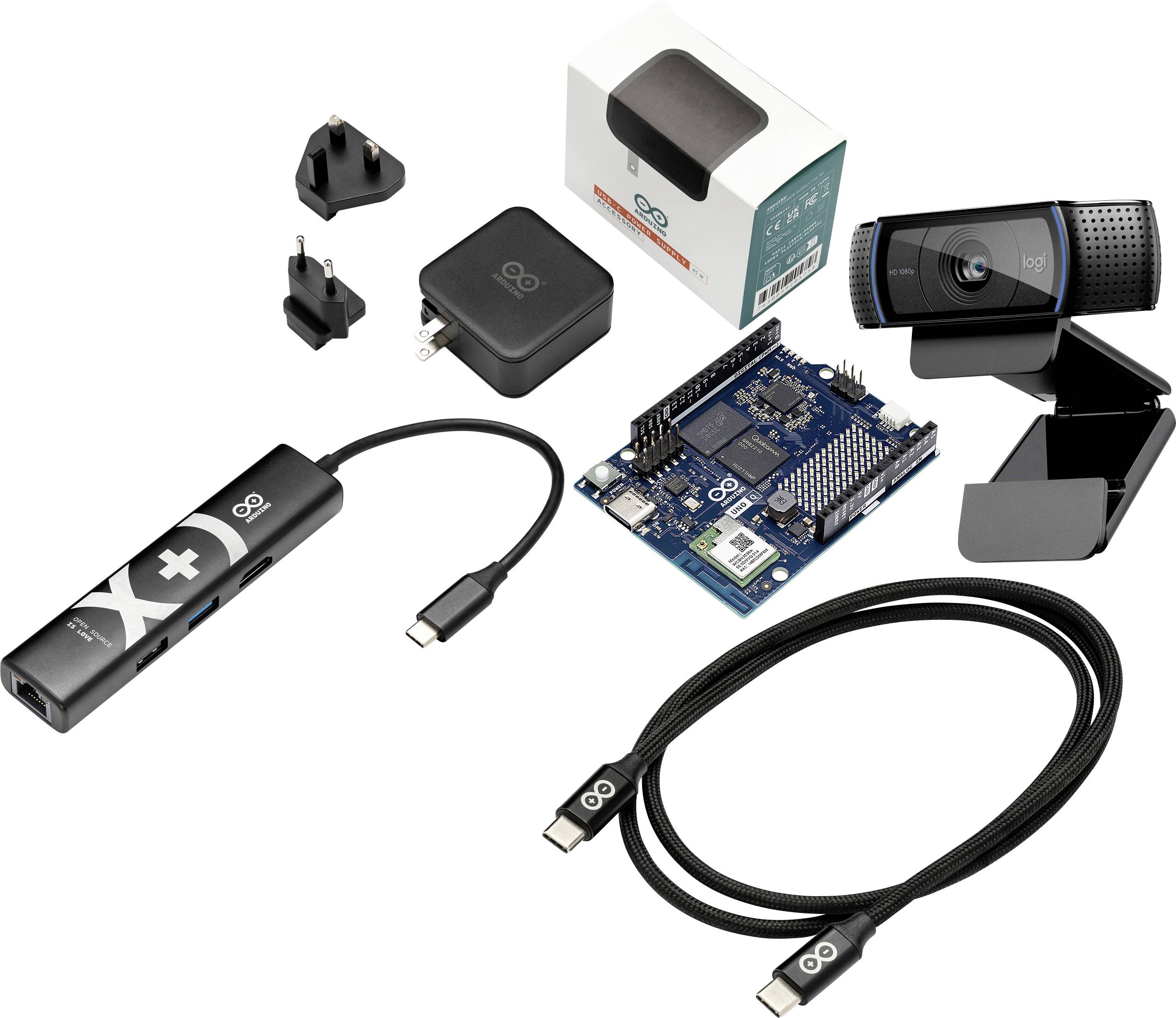 Sortiertes Elektronik-Set: Webcam, Arduino-ähnliches Board, USB-Hub und Kabel, Netzteil, Adapterstecker und Einzelhandelsverpackung auf weißem Hintergrund.
