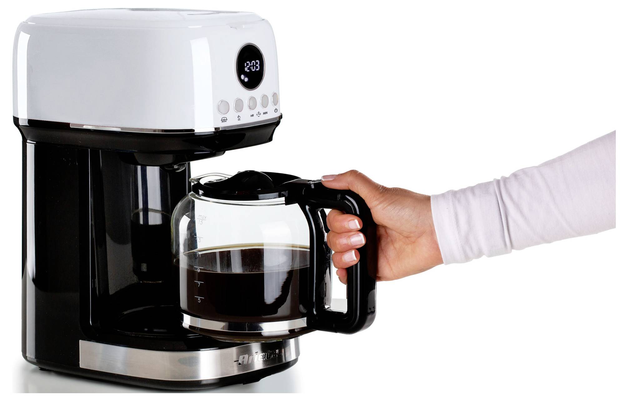 Hand, die eine Glaskaffeekanne in eine Tropfkaffeemaschine mit frischem Kaffee darin auf weißem Hintergrund einfügt.
