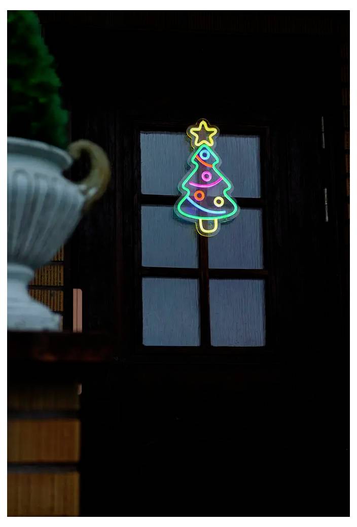 Neon-Weihnachtsbaumdekoration, die nachts in einem Fenster leuchtet, mit einem Stern an der Spitze.