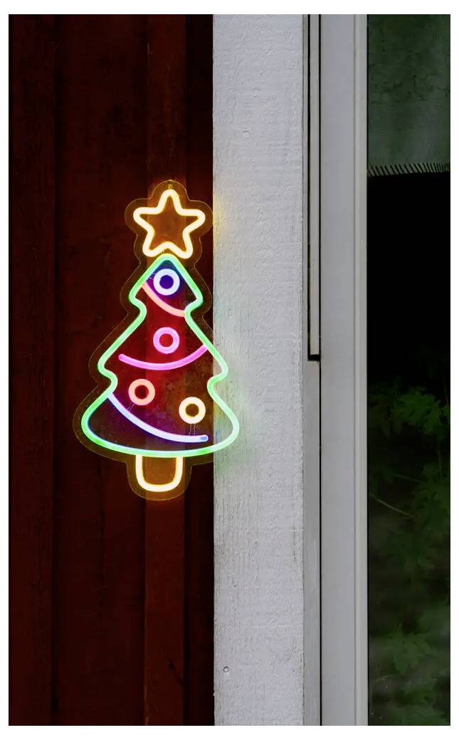 Neon-Weihnachtsbaumschild mit einem Stern, das in bunten Lichtern an einer Wand neben einem Fenster leuchtet.