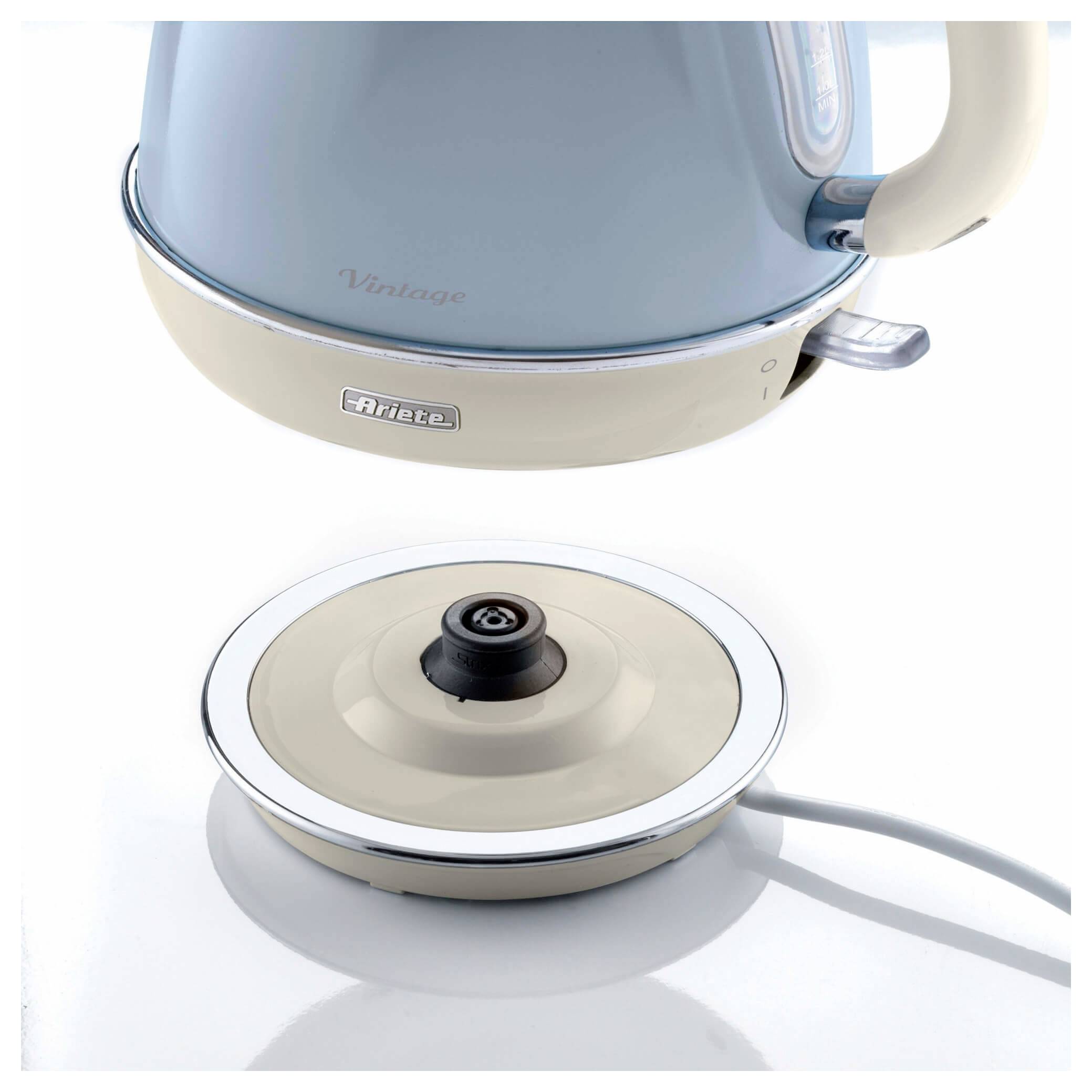 Pastell-blauer und creme-farbener elektrischer Wasserkocher, oben abgebildet, über einer passenden runden Heizplatte mit Stromkabel, angezeigt auf weißem Hintergrund.