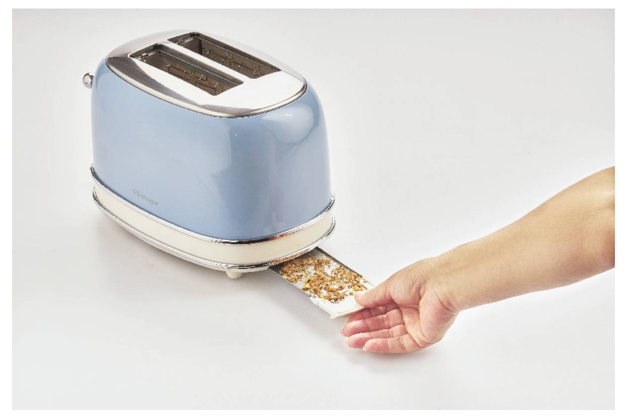 Eine Hand hält eine Scheibe Toast, die aus einem blauen Toaster auf einer weißen Oberfläche herausgedrückt wird.