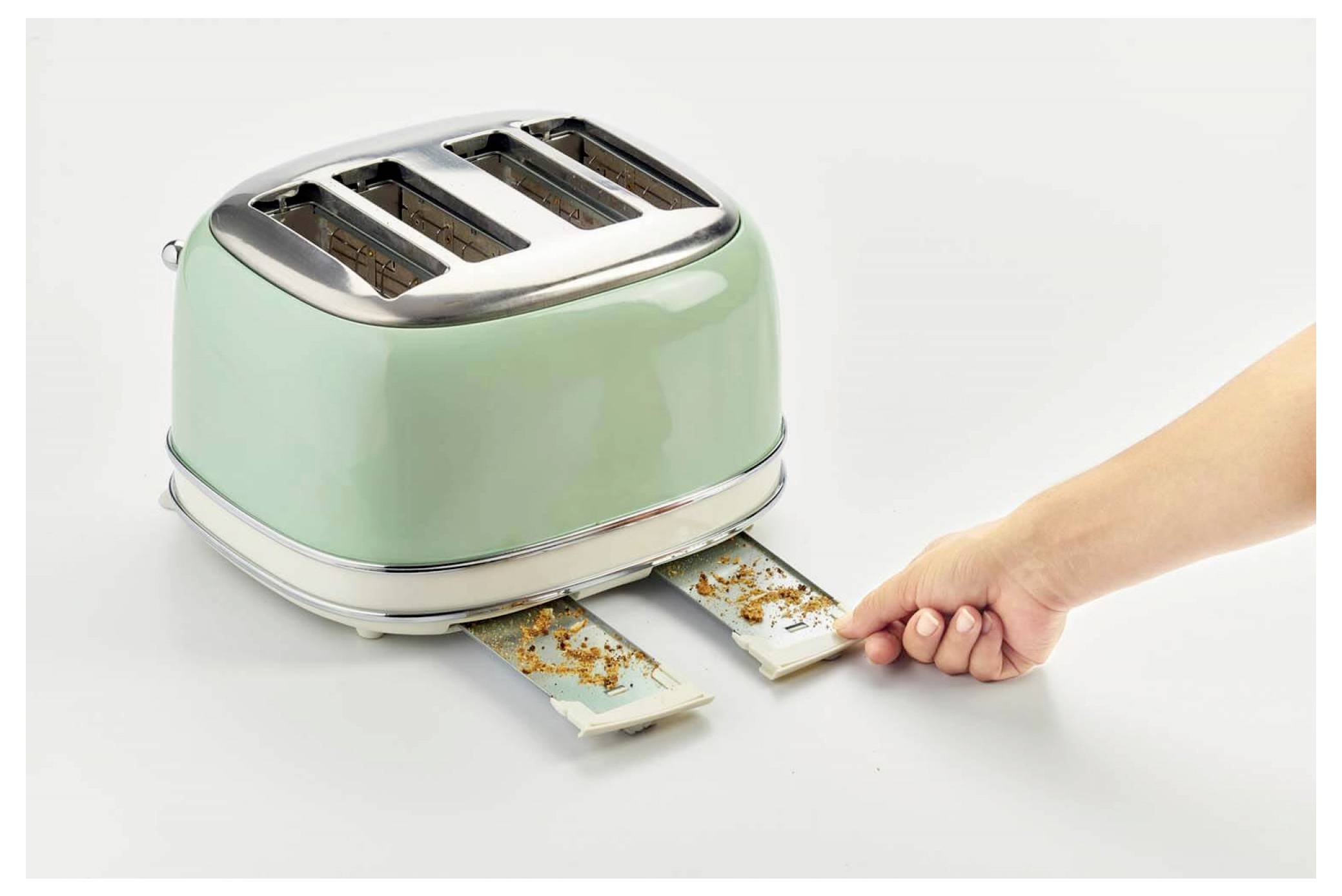 Hand zieht einen eingeklemmten Toastscheibe aus einem grünen Zwei-Schlitz-Toaster heraus, wobei Krümel herausfallen.