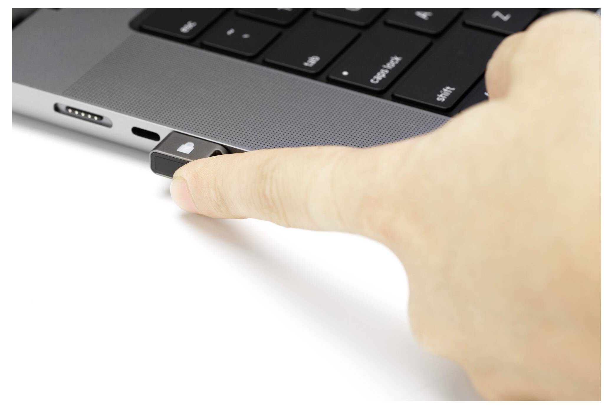 Eine Hand führt einen USB-Stick in den Seitenport eines Laptops ein.