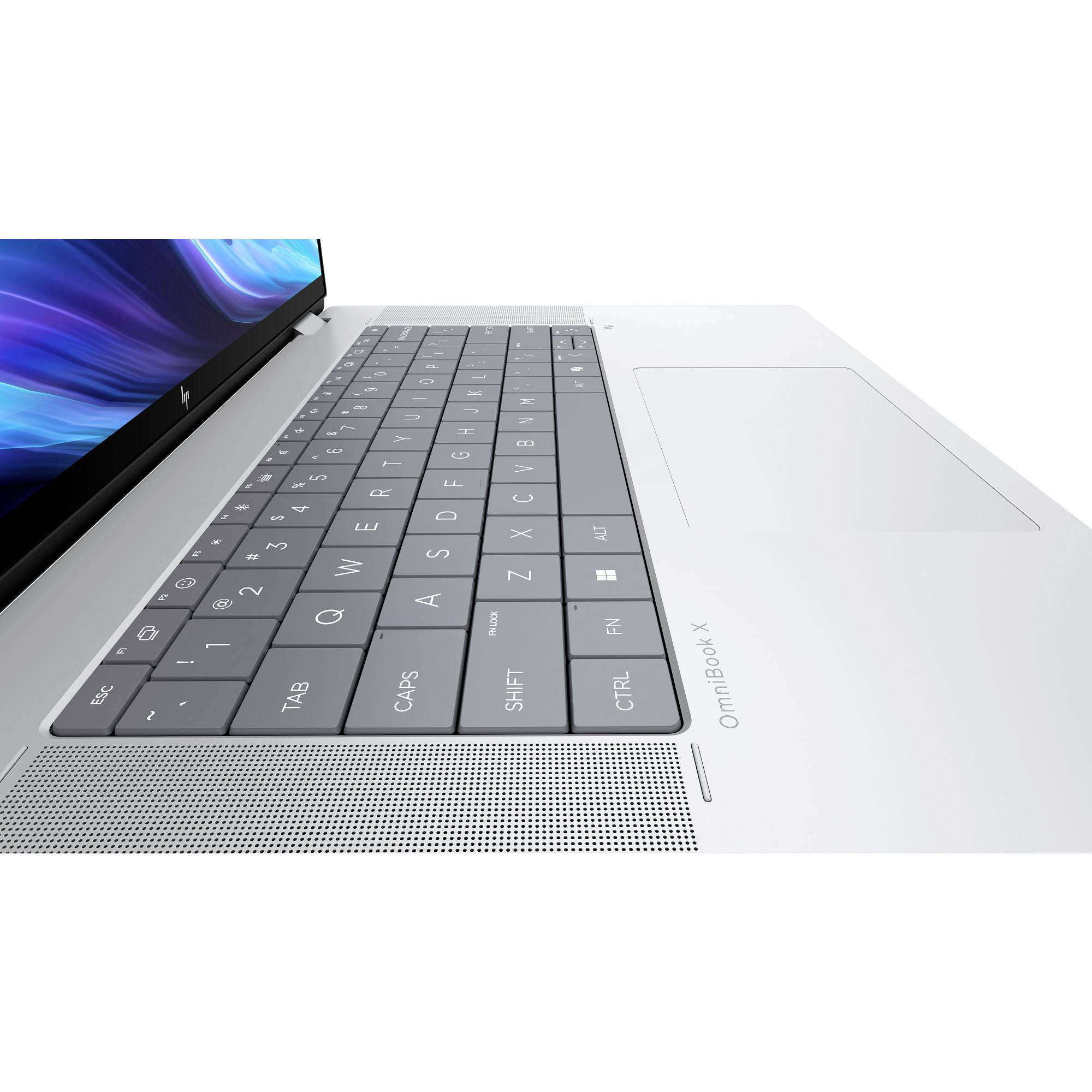 Nahaufnahme einer silbernen Laptop-Tastatur und eines Touchpads, die die linke Seite des Bildschirms und des Lautsprechergitters zeigen.