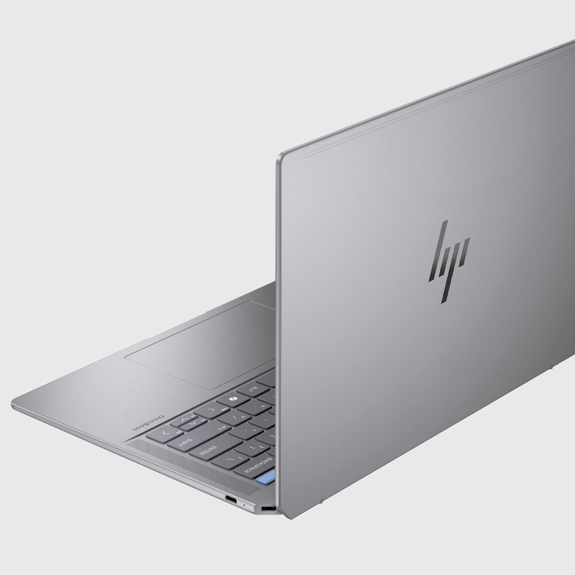 Silber-HP-Laptop, von hinten teilweise geöffnet gezeigt, mit Hervorhebung des Deckellogos, der Tastatur und des dünnen Gehäuses.
