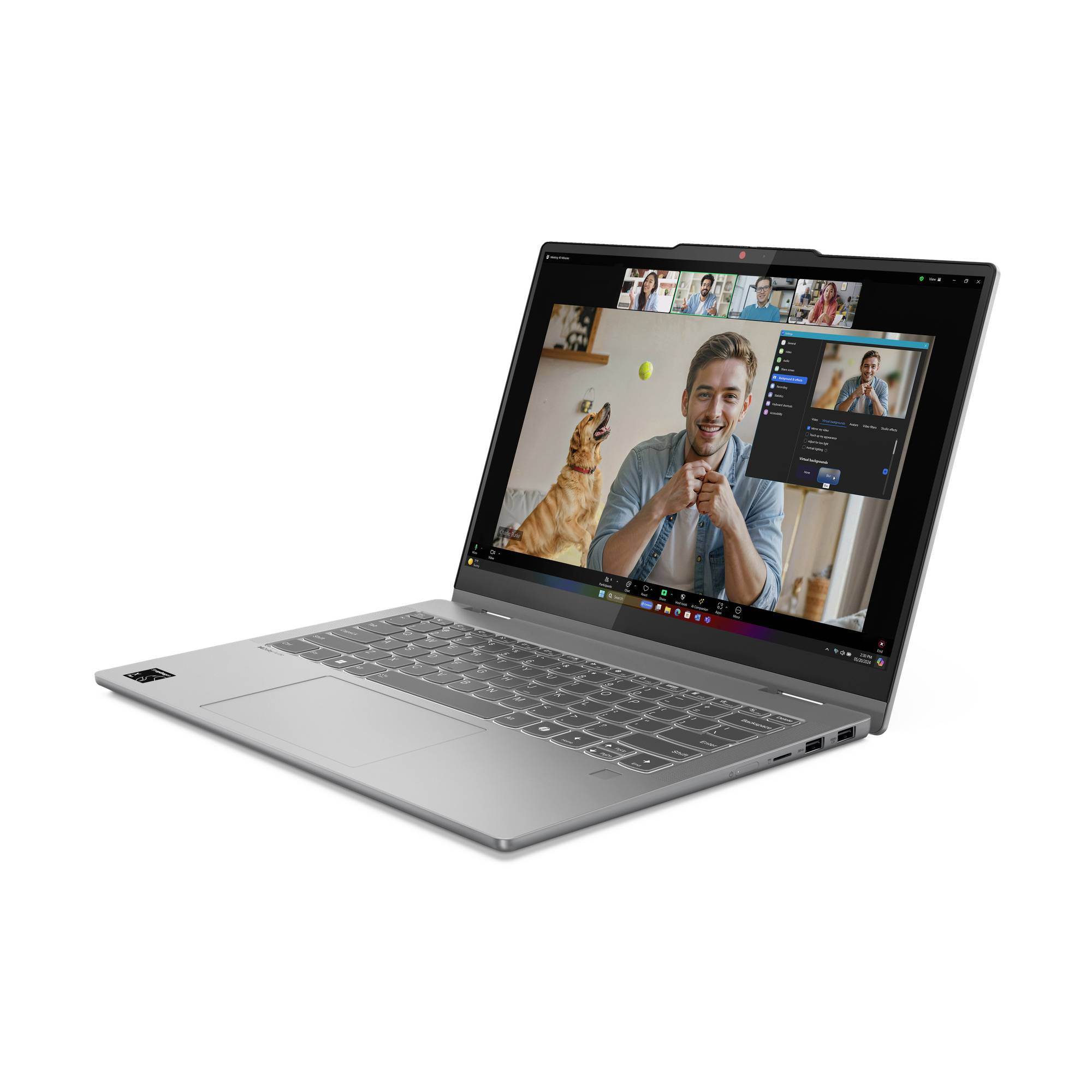 Silberner Laptop, der einen Videoanruf mit mehreren Teilnehmern zeigt, und ein Mann, der auf dem Bildschirm mit einem Hund spielt.