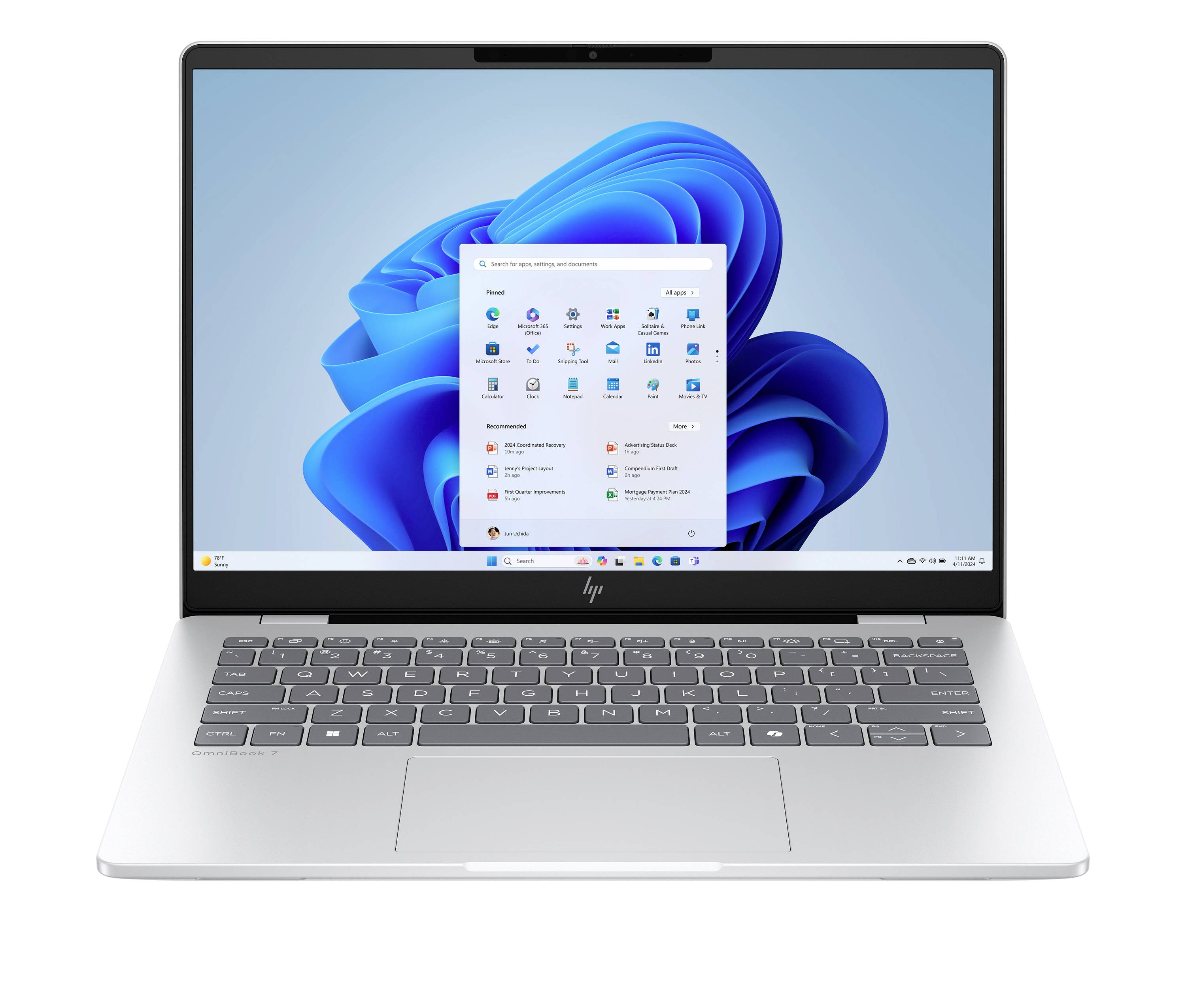 Silberner Laptop mit Windows 11-Desktop und geöffnetem Startmenü auf dem Bildschirm.