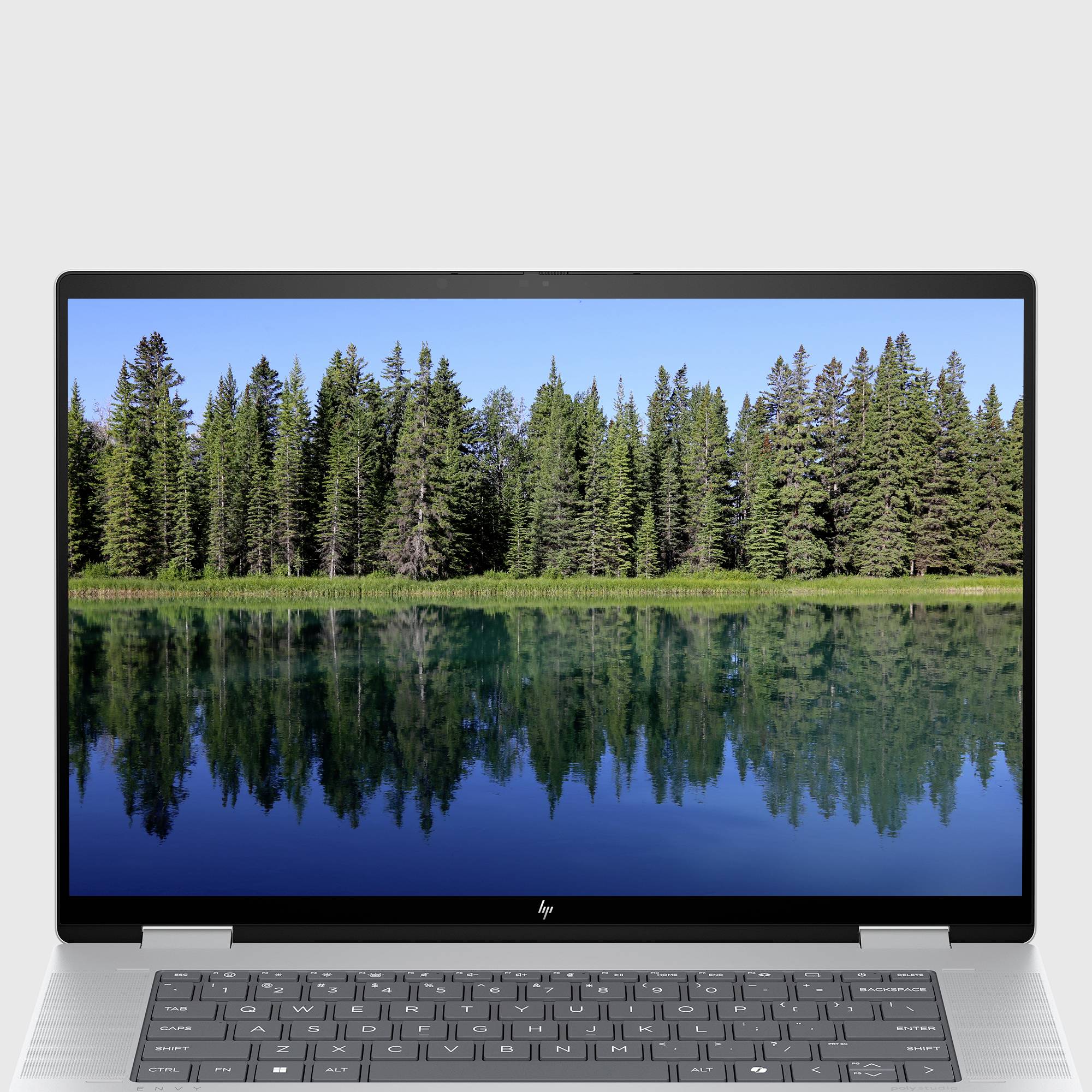 Der Laptop-Bildschirm zeigt einen malerischen See mit immergrünen Bäumen, die sich in ruhigem Wasser spiegeln.