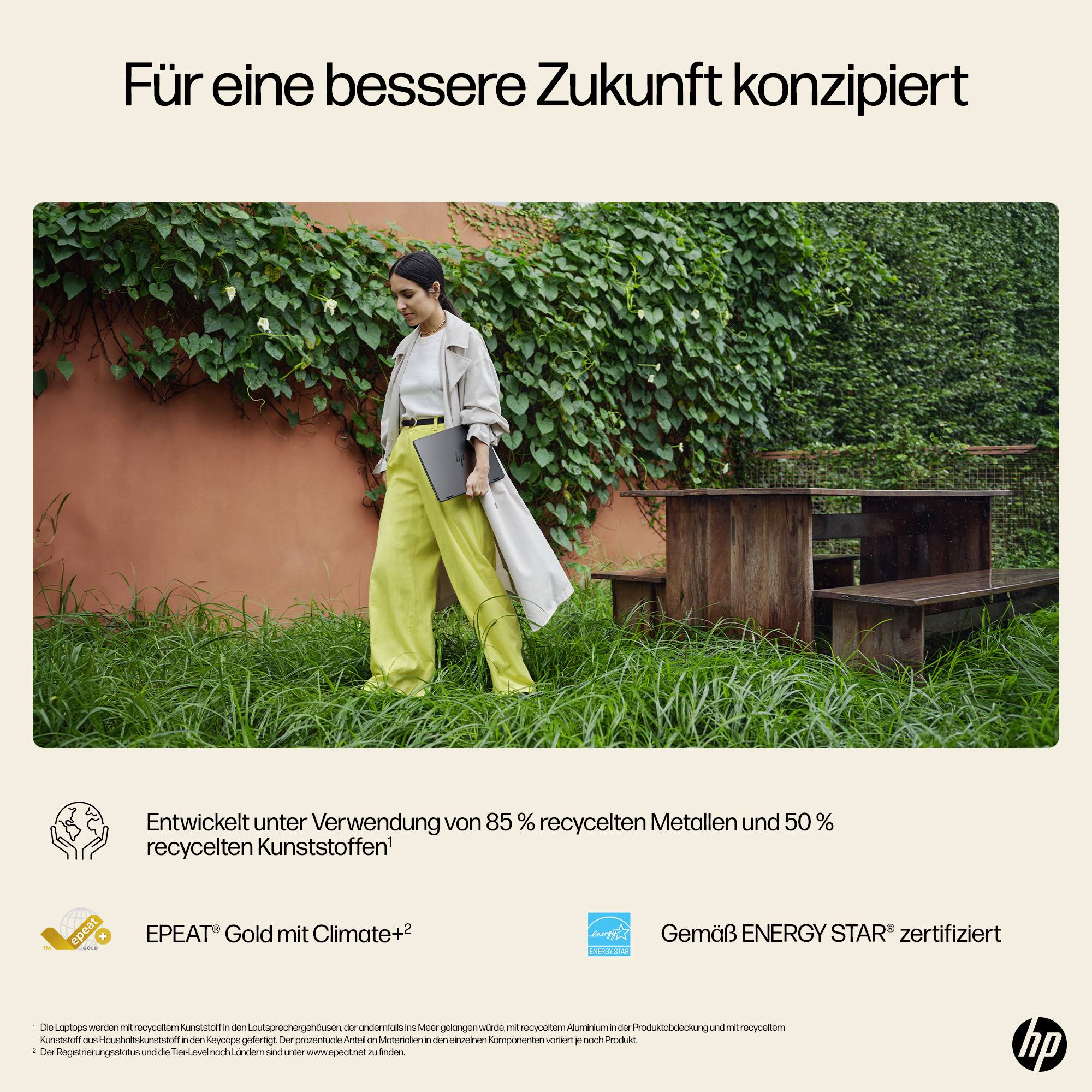 # HP Nachhaltigkeitsanzeige mit einer Person in einem Garten; Text besagt „Für eine bessere Zukunft konzipiert" und vermerkt 85% recycelte Metalle, 50% recycelte Kunststoffe, EPEAT Gold, ENERGY STAR zertifiziert.