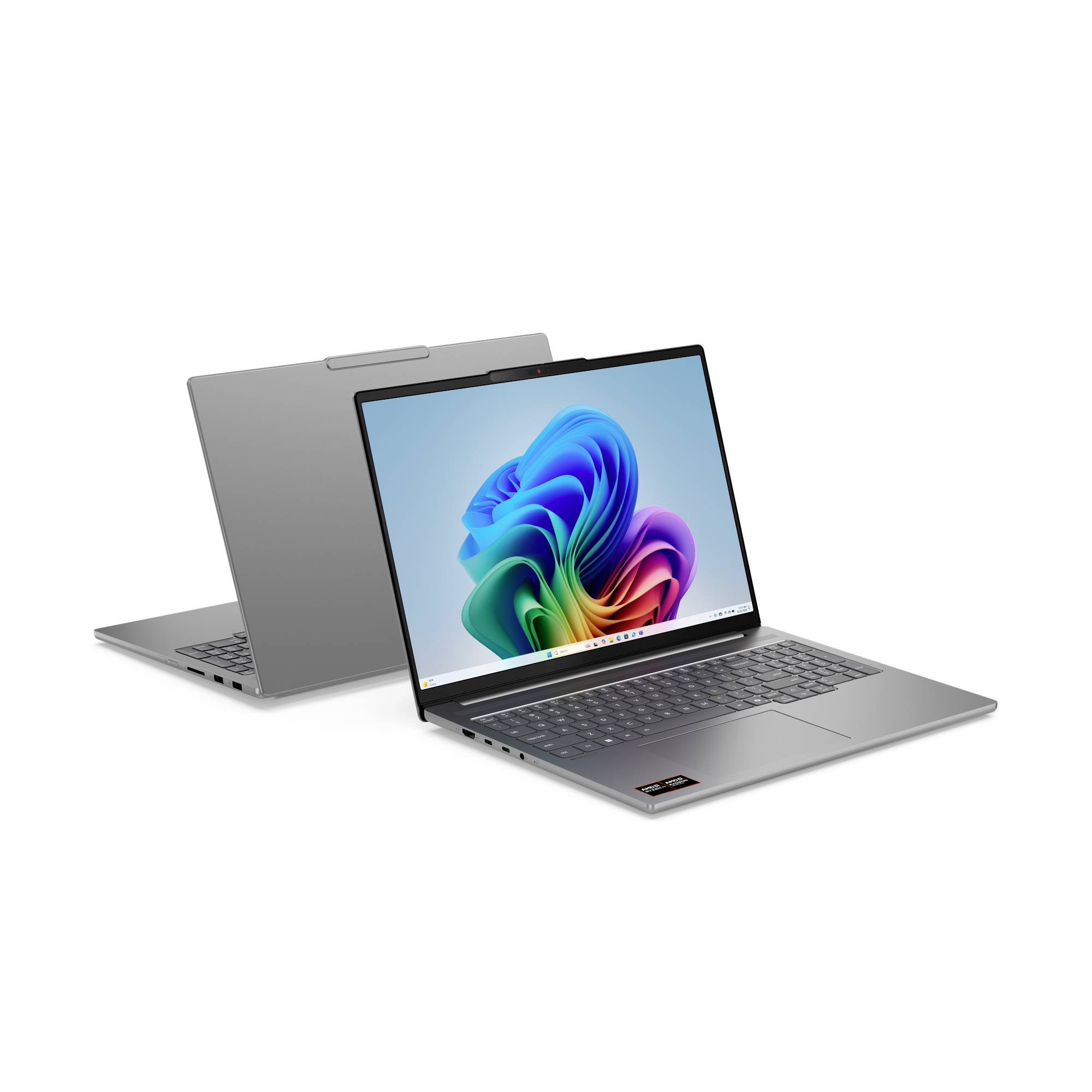 Zwei silberne Laptops, einer offen mit einem farbenfrohen abstrakten Windows-ähnlichen Hintergrundbild und einer geschlossen dahinter auf weißem Hintergrund.