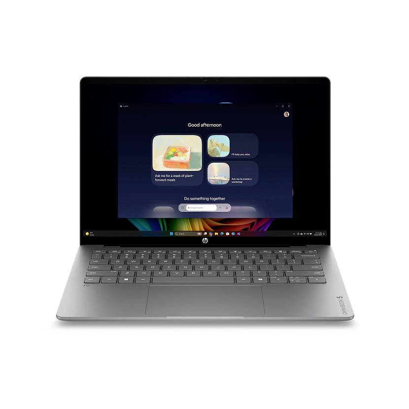 Ein silberner Lenovo-Laptop auf weißem Hintergrund zeigt einen dunklen Startbildschirm mit „Guten Nachmittag" und App-Kacheln an.