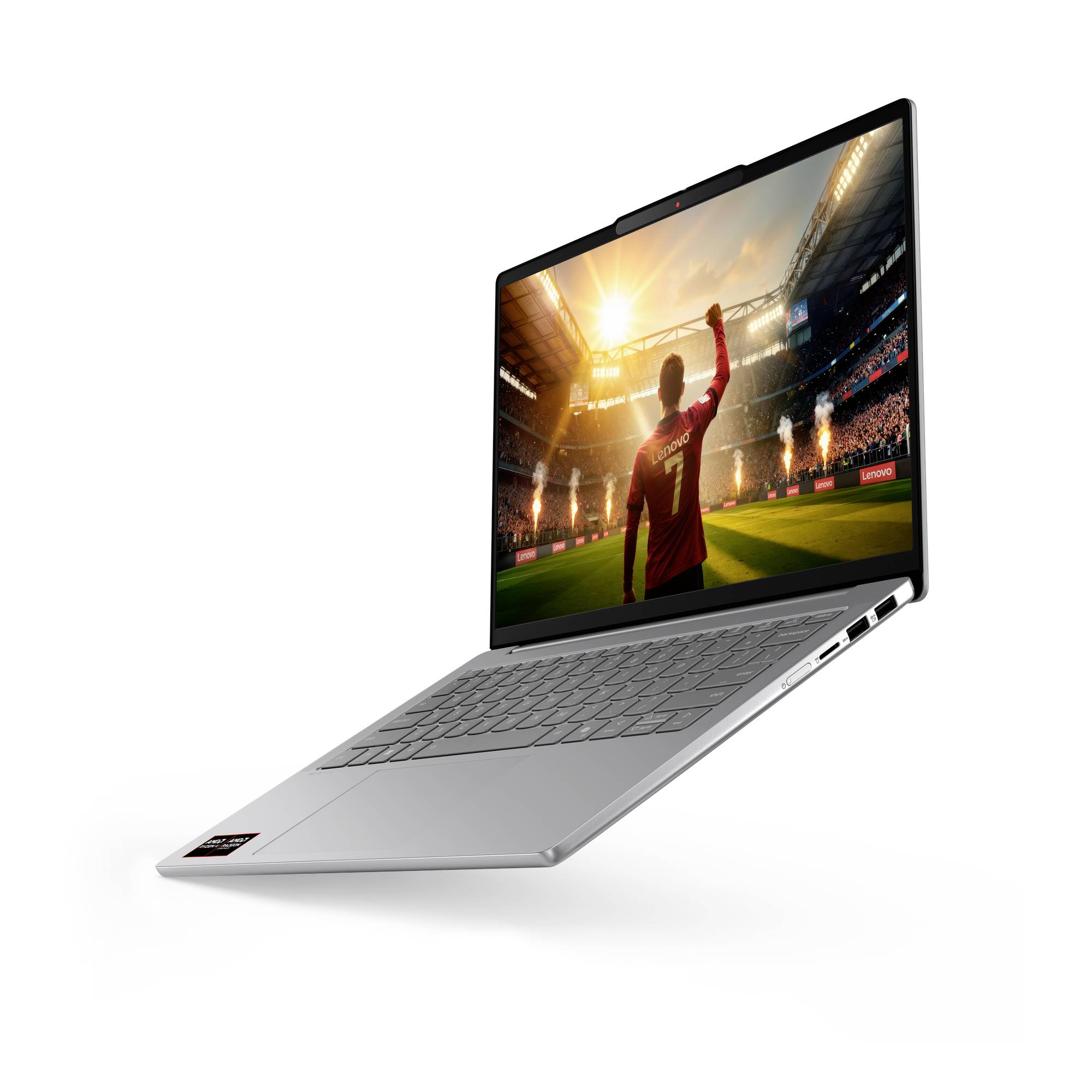 Silberner Laptop, schräg geöffnet, zeigt einen Fußballspieler in einem Stadion auf dem Bildschirm.