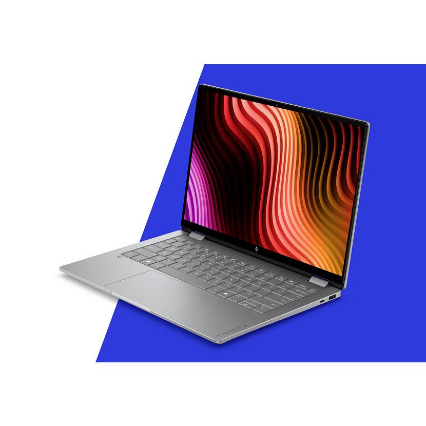 Silberner Laptop in einem Winkel geöffnet, der ein farbenfrohe abstrakte wellige Anzeige vor einem blauen geometrischen Hintergrund zeigt.
