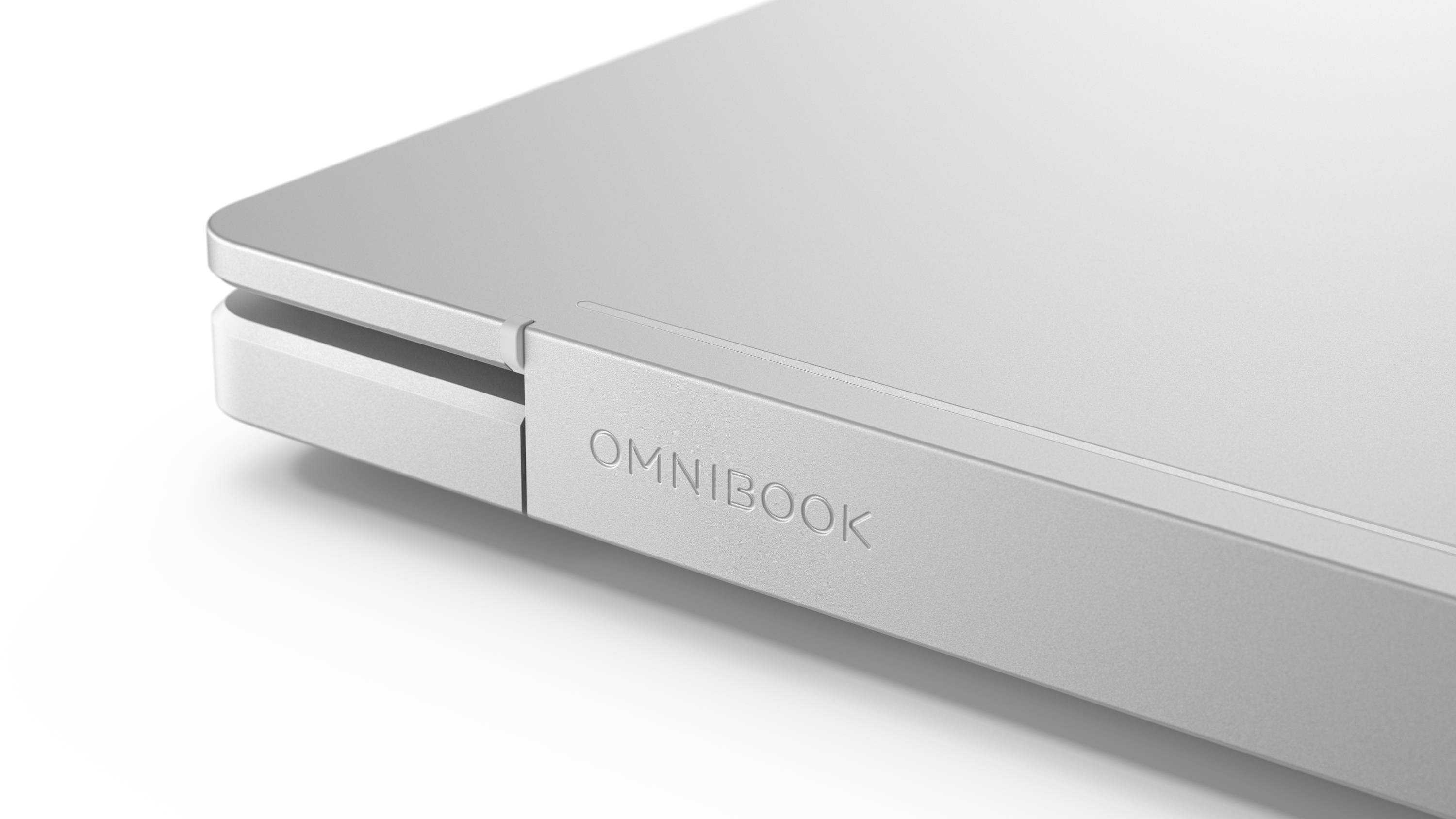 Nahaufnahme eines silbernen Omnibook-Laptop-Deckels und der vorderen Kante, die das Scharnier und das geprägte "OMNIBOOK"-Logo zeigt.