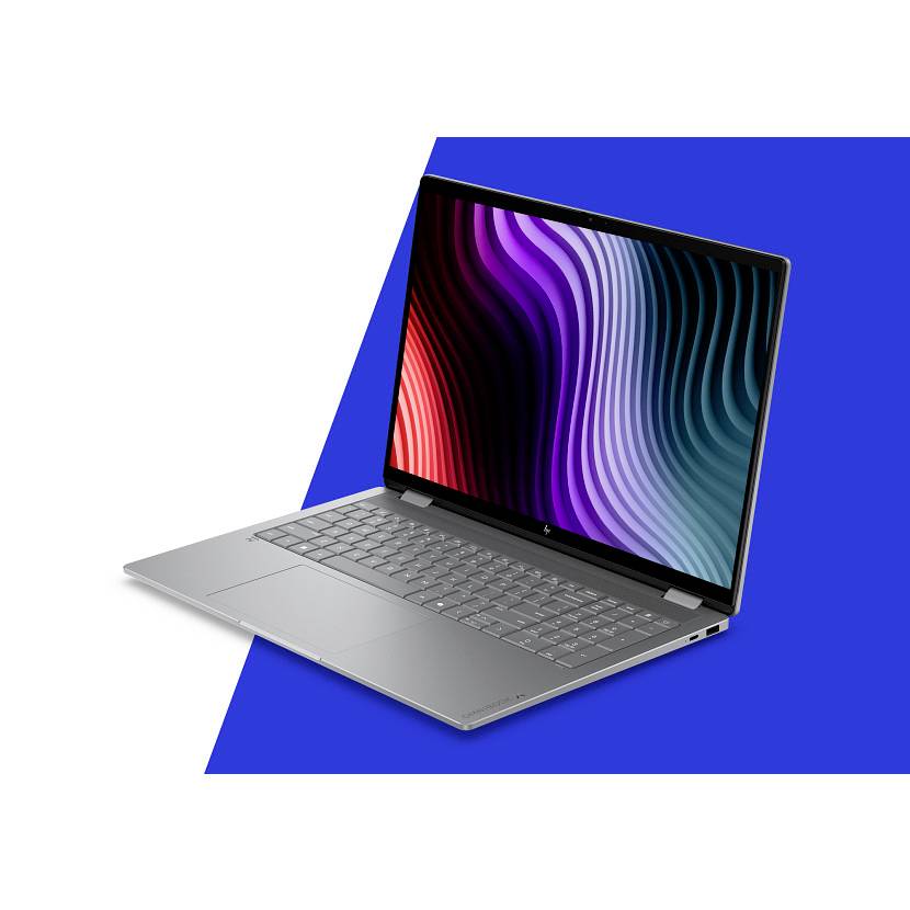 Silberner Laptop schräg geöffnet auf einem blauen geometrischen Hintergrund, mit einem farbenfrohen wellenförmigen abstrakten Display.