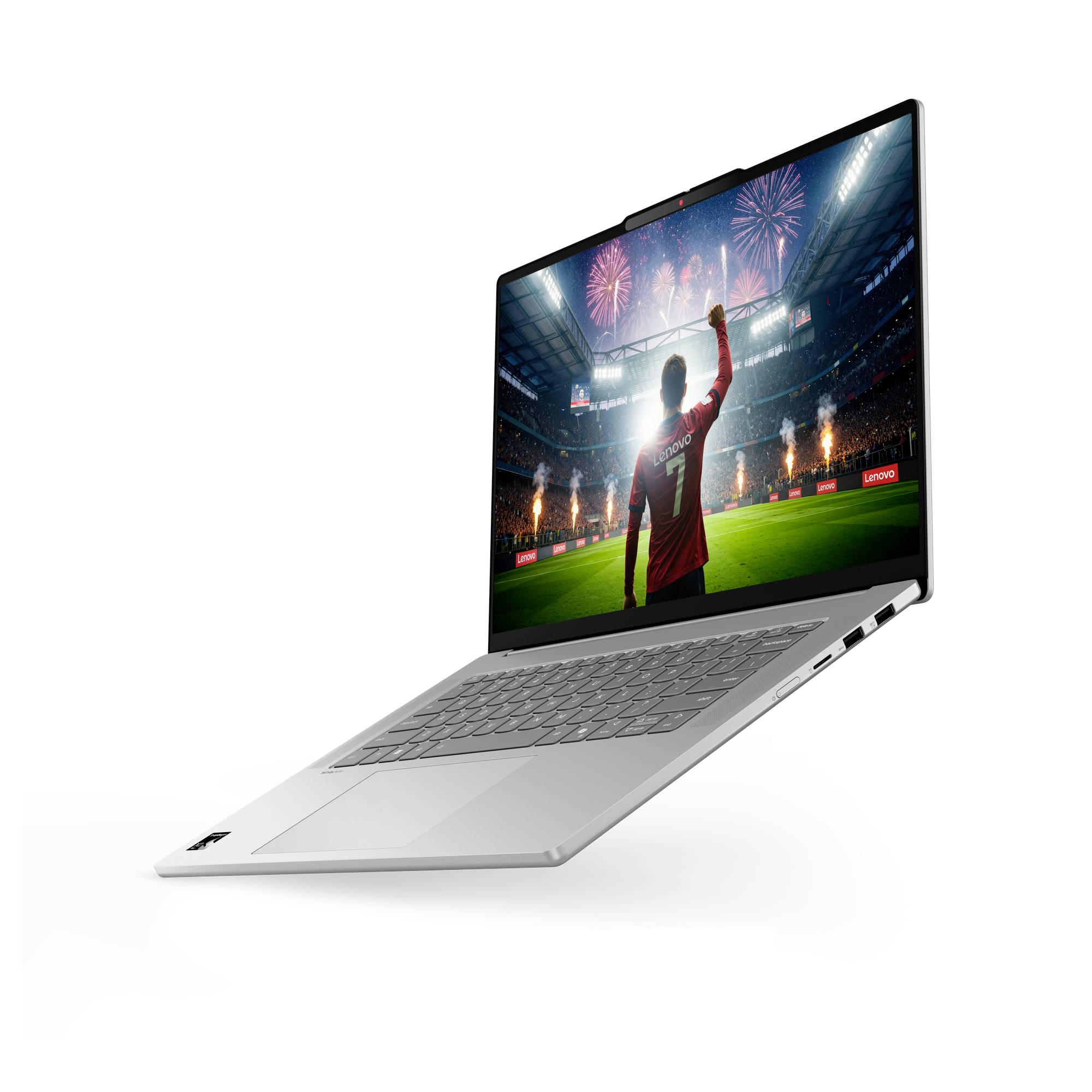 Silberner Laptop, der offen angezeigt wird und einen Fußballspieler zeigt, der in einem Stadion mit Feuerwerk auf dem Bildschirm feiert.