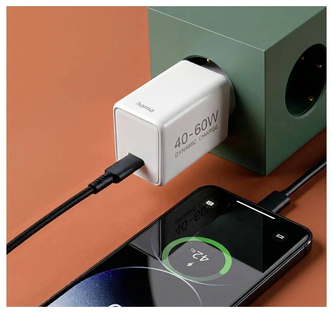 Weißes 40-60W Ladegerät in einen grünen Block gesteckt und lädt ein Smartphone, wobei der Batteriestand auf dem Bildschirm angezeigt wird.