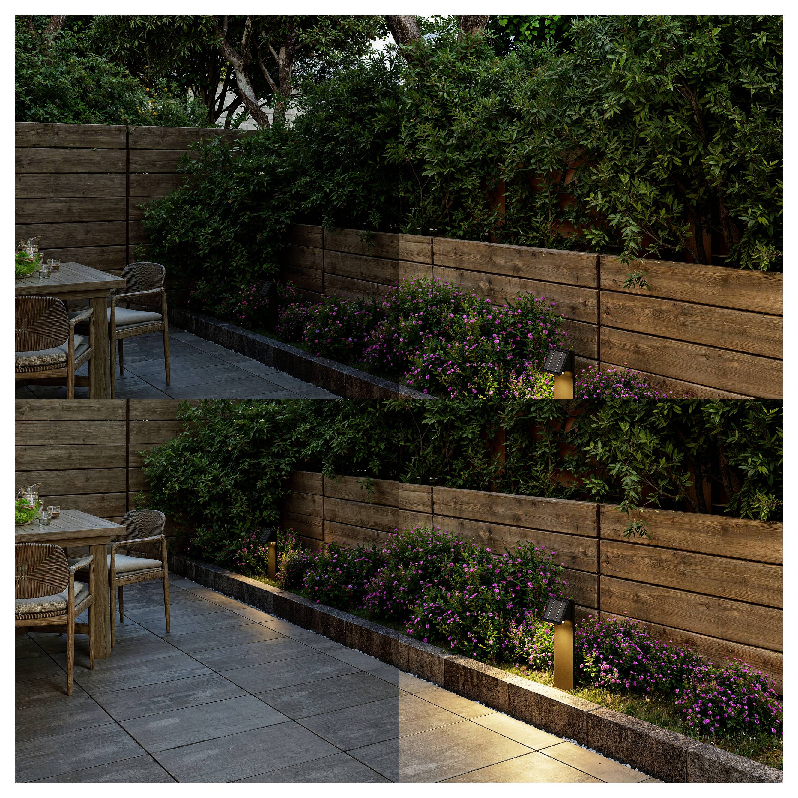 Moderner Patio mit Holz-Sichtschutzwand, üppigem Grün, rosa Blüten und sanfter Bodenbeleuchtung neben einem kleinen Gartenesstisch