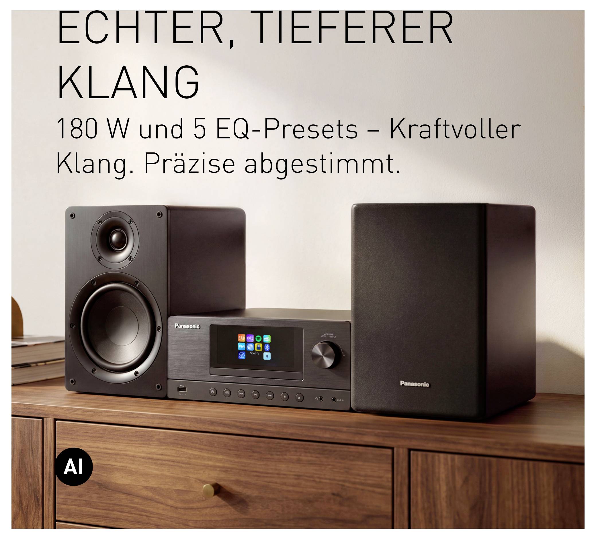 Panasonic-Stereosystem mit zwei Lautsprechern und Display-Einheit auf einem Holzschrank, mit deutschem Text, der "strafferen, tieferen Sound" und 180W mit 5 EQ-Voreinstellungen bewirbt.