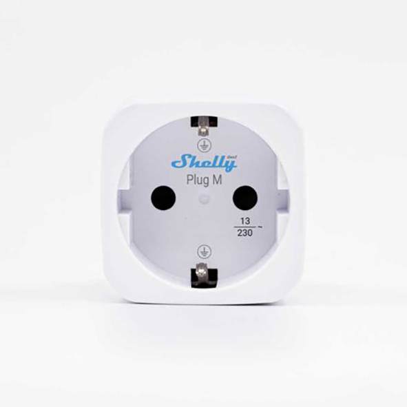 Frontansicht eines weißen Shelly Plug M Smart-Plug-Adapters mit zwei runden Steckerlöchern und der Markierung „13 230~" auf einem weißen Hintergrund.